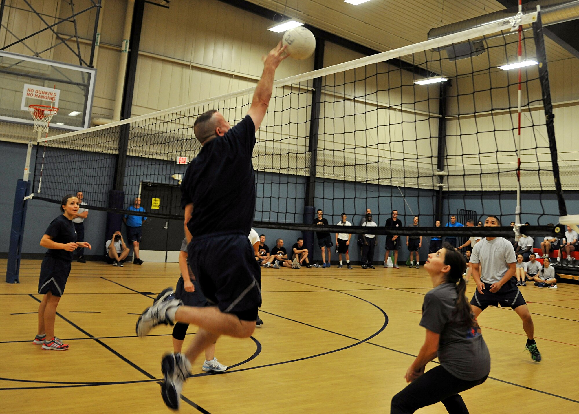 319th Air Base Wing Command Chief Master Sgt. David Duncan hits a ball across the net against the 319th Medical Operations Squadron team during the Summer Bash 4-on-4 volleyball tournament Aug. 21, 2014, on Grand Forks Air Force Base, N.D. 319th Wing Staff Agencies placed second for the small unit category out of 11 competing units. (U.S. Air Force photo/Senior Airmen Xavier Navarro)