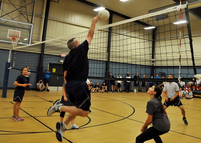 319th Air Base Wing Command Chief Master Sgt. David Duncan hits a ball across the net against the 319th Medical Operations Squadron team during the Summer Bash 4-on-4 volleyball tournament Aug. 21, 2014, on Grand Forks Air Force Base, N.D. 319th Wing Staff Agencies placed second for the small unit category out of 11 competing units. (U.S. Air Force photo/Senior Airmen Xavier Navarro)
