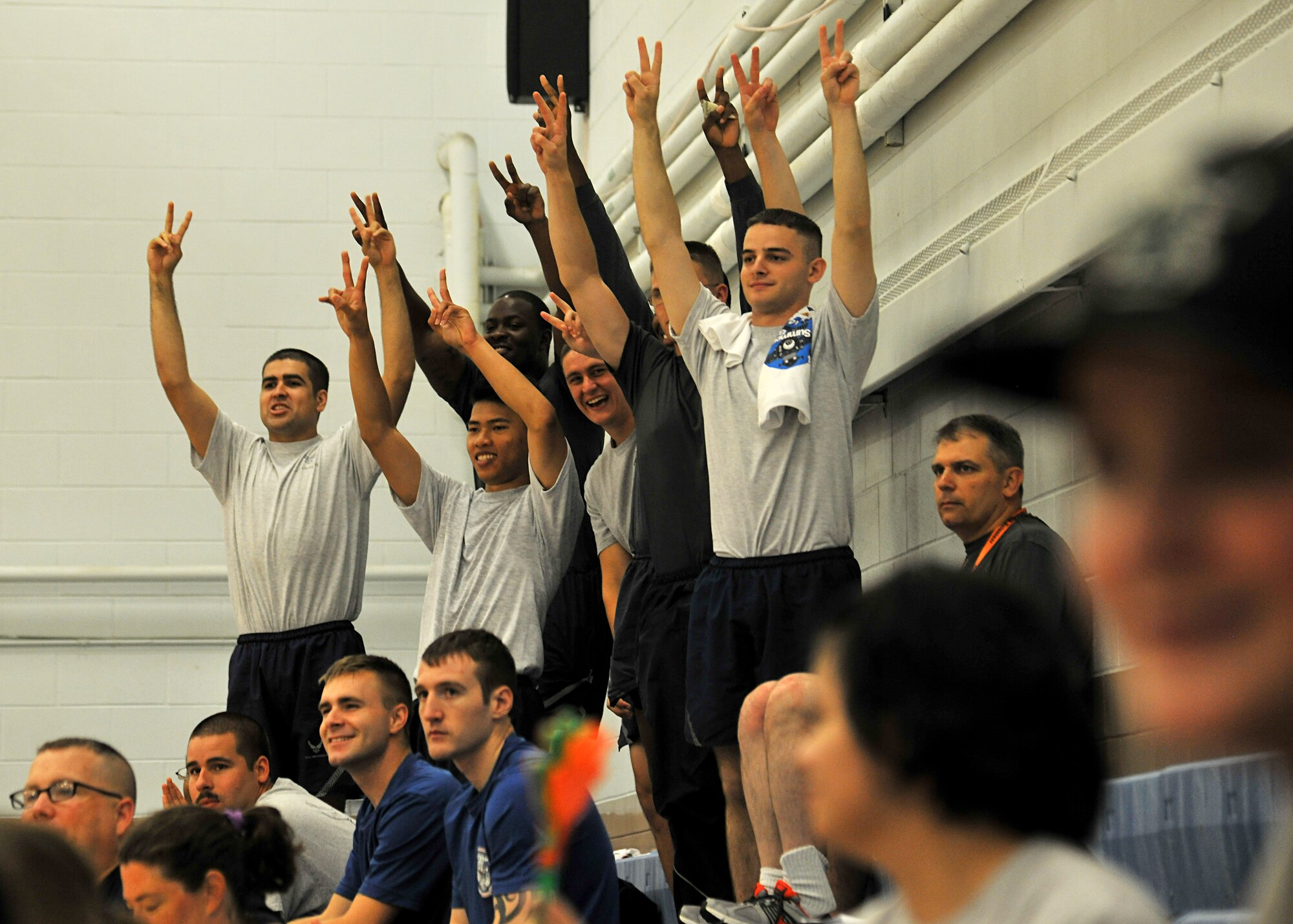 Airmen of the 319th Air Base Wing stand up in response to how many strikes a team has during the Summer Bash kickball tournament on Aug. 21, 2014, on Grand Forks Air Force Base, N.D. More than 750 spectators attended Summer Bash in which 11 units competed in 14 different fitness events. (U.S. Air Force photo/Senior Airman Xavier Navarro)
