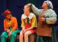 Jiminy Cricket (Alex Miranda, left) examines Pinocchio (Faith Quinslisk, center) after toymaker Mrs. Geppetto puts the final touches on her masterpiece wooden boy. The play “PINOCCHIO” ran Aug. 22 at the Malmstrom Air Force Base auditorium, and was presented by the 341st Force Support Squadron’s Youth Programs and the Missoula Children’s Theatre. (U.S. Air Force photo/John Turner)