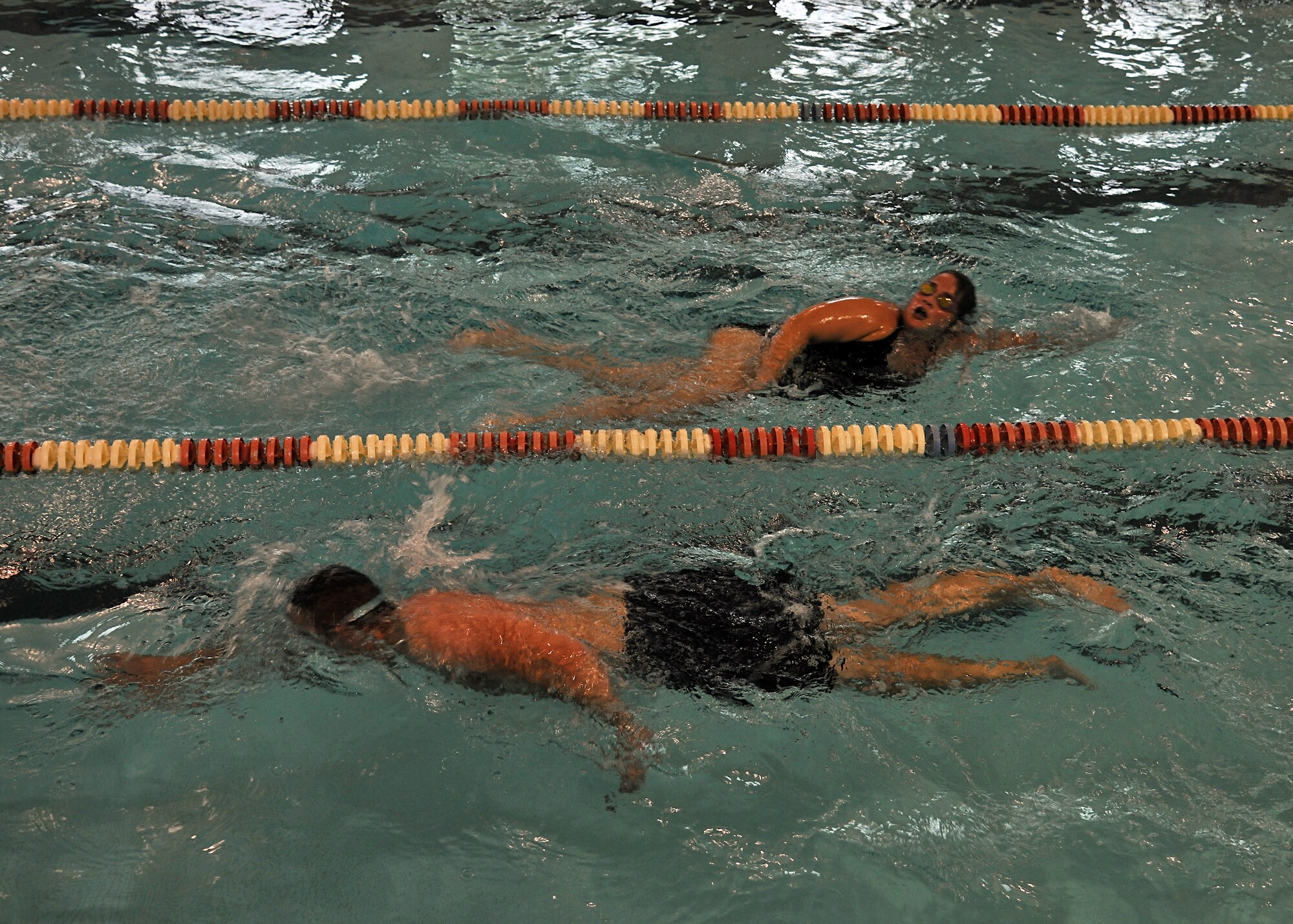 319th Air Base Wing airmen swim in the fitness center pool during the swim a mile event for Summer Bash, Aug. 21, 2014, on Grand Forks Air Force Base, N.D. Marvin Regorrah, 319th Contracting Flight chief plans and programs, swam 1,600 meters in 23 minutes and 49 seconds, winning first place for the male category. Airman 1st Class Irinieta Tabuyaqona, 319th Contracting Flight contract specialist, swam 1,600 meters in 30 minutes and 30 seconds winning first place for the female category. (U.S. Air Force photo/Senior Airman Xavier Navarro) 
