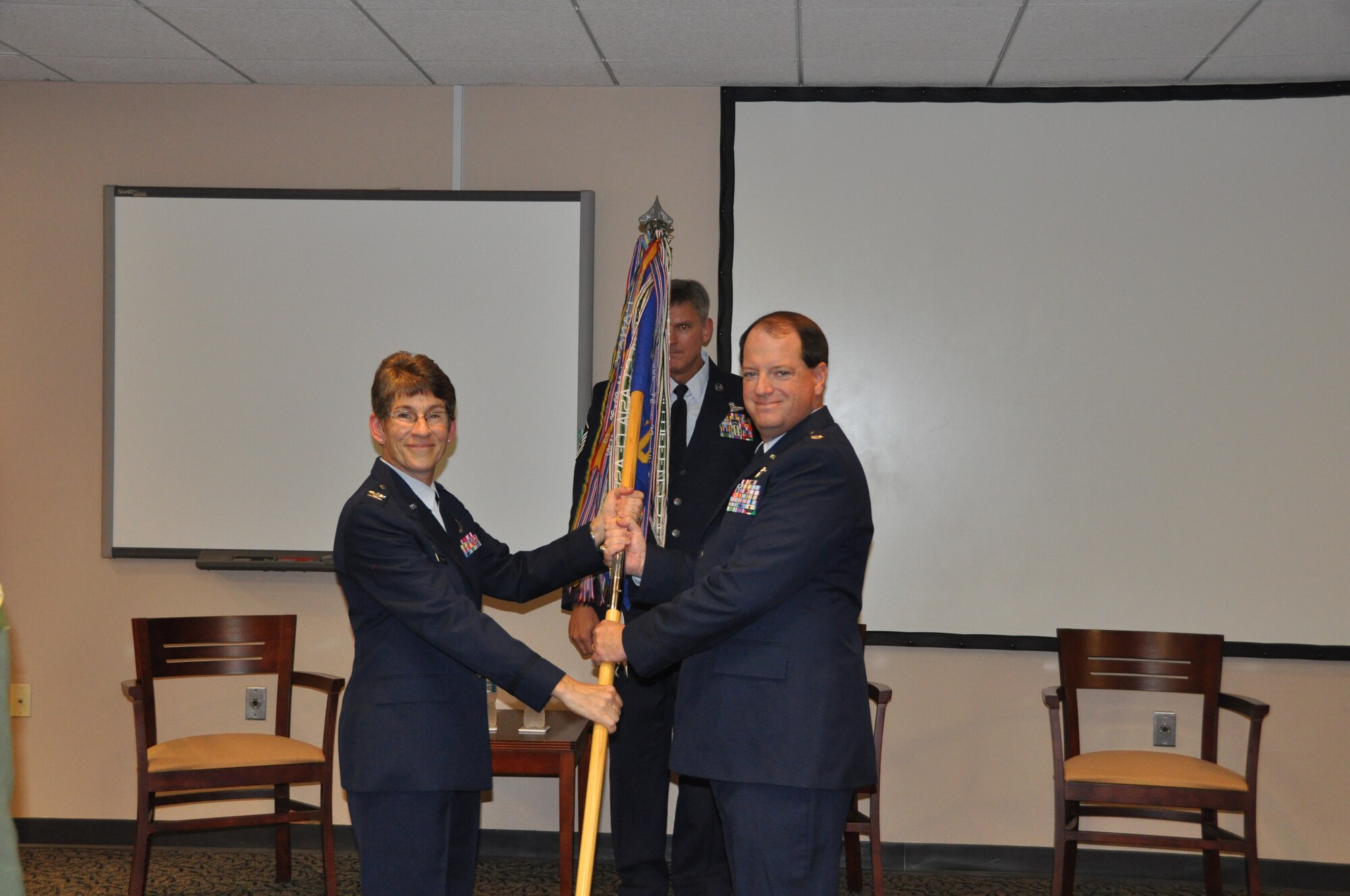Col. Caroline Evernham, 315th Operations Group commander, passes the guidon to Lt. Col. Thomas McNamara as he assumes command of the 701st Airlift Squadron during a ceremony Aug. 24, 2014 in the Yonkie Auditorium here at Joint Base Charleston, S.C. McNamara was previously the 315th Operations Support Squadron commander before taking command of the 701st AS. (U.S. Air Force photo / Capt. Michaela Judge)