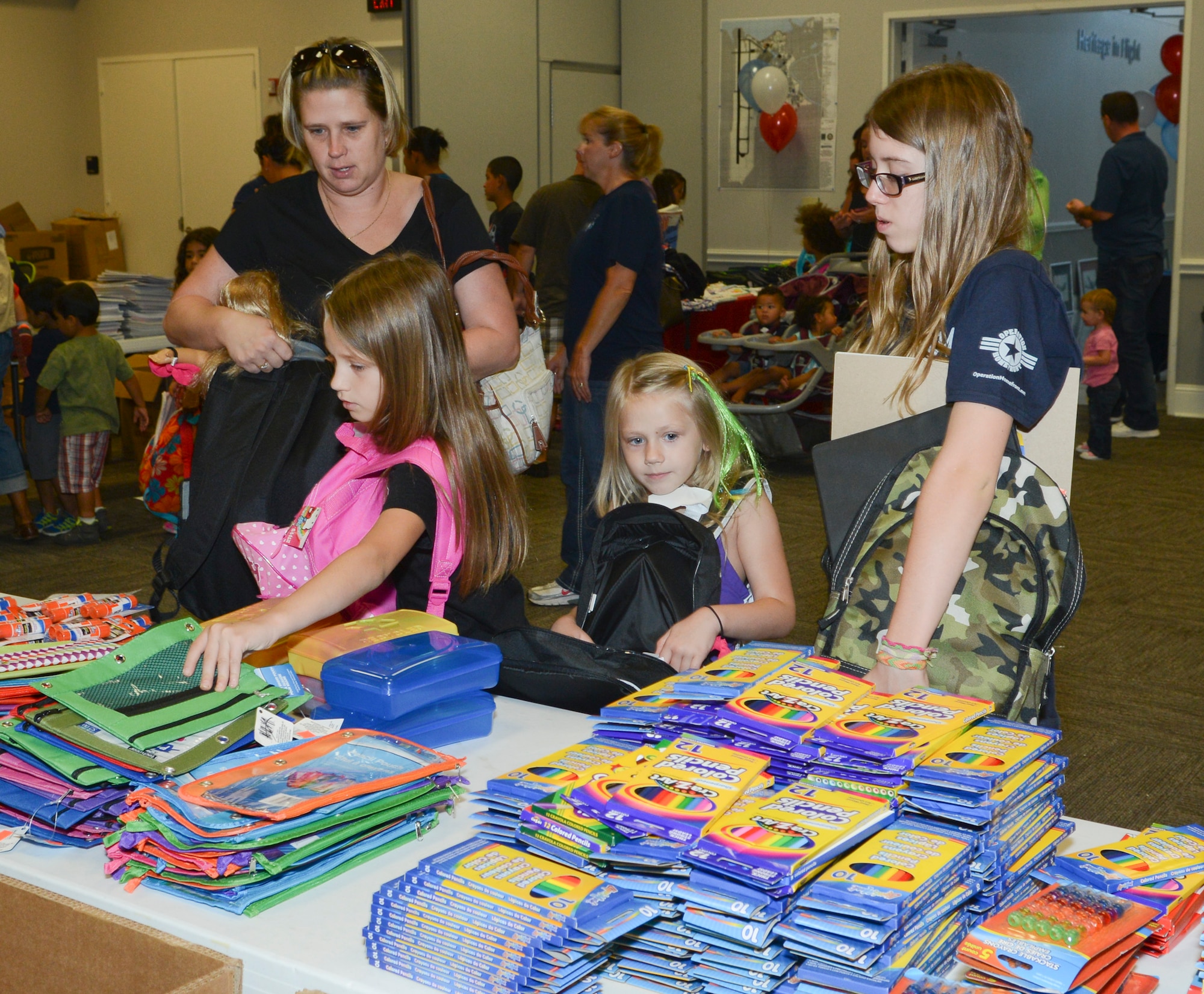 Military families of E-6 and below with school age children from K-12 browse through the many school-supply itmes with their brand new packpacks, filling them with up to 30 items at the 136th Airlift Wing, Naval Air Station Fort Worth Joint Reserve Base, Texas, Aug.15, 2014. Operation Homefront Back Pack Brigade partners with Dollar Tree and Office Depot poviding the free school supplies to military kids. (Air National Guard photo by Senior Master Sgt. Elizabeth Gilbert/released)
