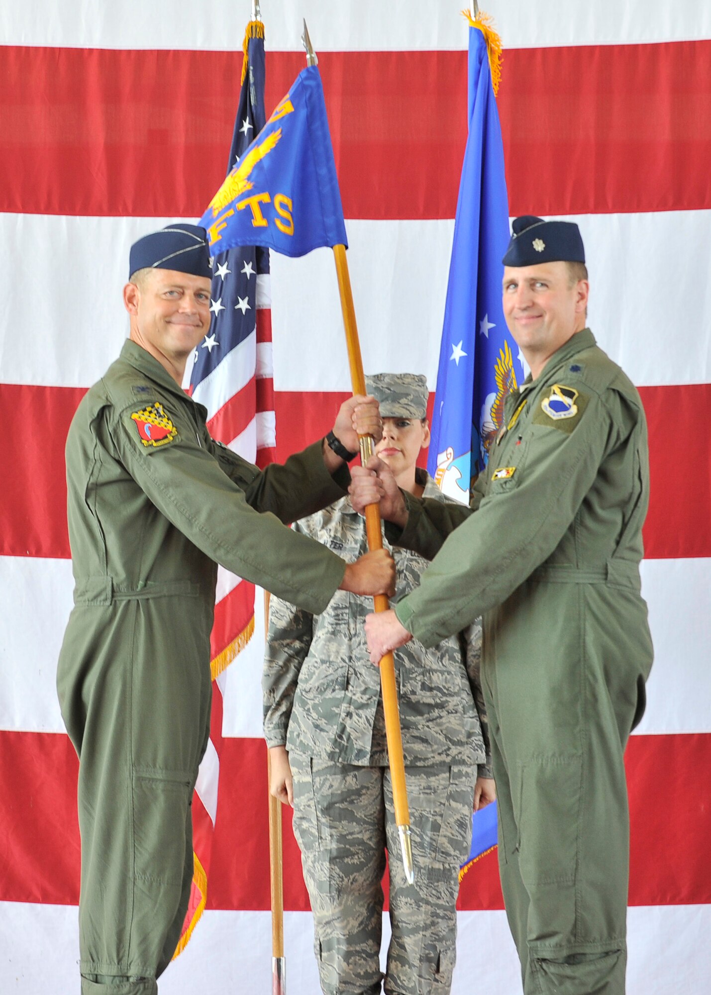 Col. Max Marosko, 325th Operations Group commander, passes the 2nd Fighter Training Squadron guidon to Lt. Col. Derek Wyler during the 2nd FTS change of command ceremony, Aug. 22, 2014, at Tyndall AFB, Fla. (U.S. Air Force photo by Airman 1st Class Sergio Gamboa)