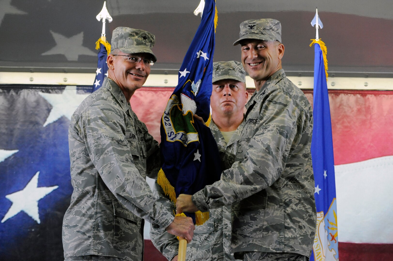 Brig. Gen. Bob LaBrutta (left), 502nd Air Base Wing and Joint Base San Antonio commander, passes the guidon to Col. Michael Gimbrone, incoming 502nd Security Forces and Logistics Support Group commander, Aug. 26, 2014 at JBSA-Randolph Hangar 73. As the 502nd SFLSG commander, Gimbrone will oversee the 502nd Security Forces Squadron, 802nd SFS, 902nd SFS, 502nd Logistics Readiness Squadron and 502nd Trainer Development Squadron. Gimbrone most recently served as deputy chief of the Force Protection Division and chief of the Asset Protection Branch in the Joint Staff Force Structure, Resources and Assessment Directorate at the Pentagon. (U.S. Air Force photo by Desiree Pilacios)