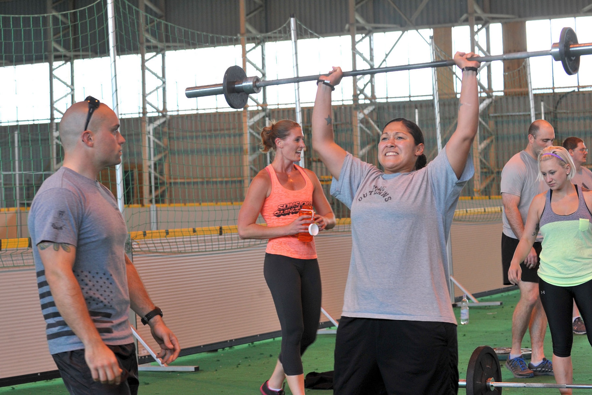 U.S. Army Sgt. Morgan Whitman, U.S. Africa Command all source analyst from Andover, Minn., watched as U.S. Army Sgt. 1st Class Deborah Landeros, U.S. European Command intelligence analyst, performs a thruster during the Coe Hero workout of the day at RAF Molesworth, United Kingdom, Aug. 14, 2014. Landeros was stationed with U.S. Army Sgt. Keith Adam Coe when he died during his deployment to Iraq and wanted to support the event in his honor. (U.S. Air Force photo by Staff Sgt. Ashley Hawkins/Released)