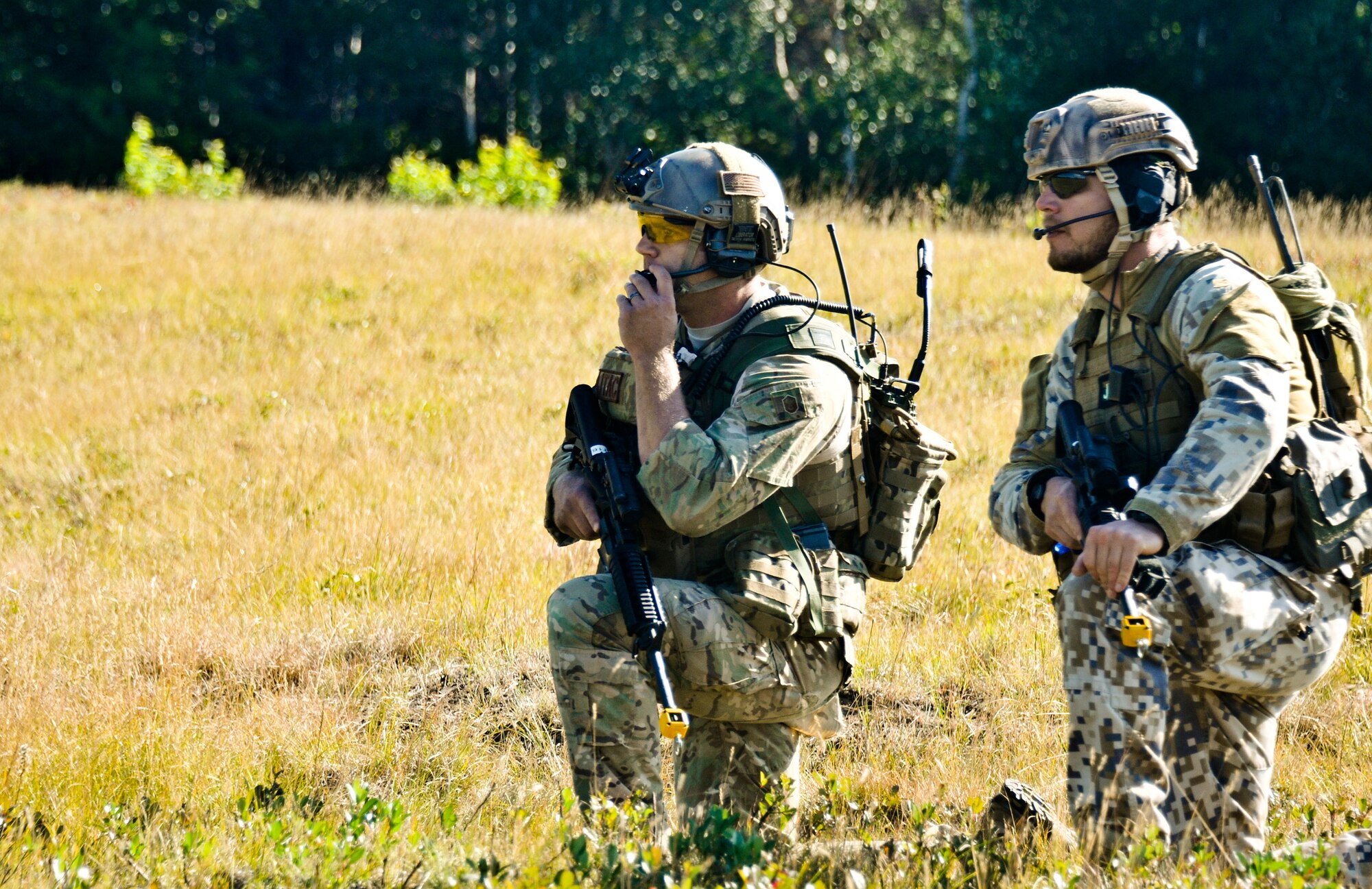 U.S. Air Force Master Sgt. John M. Oliver (left), tactical air control party specialist with the 169th Air Support Operations Squadron, and Latvian 1st Sgt. Modris Circenis, TACP with the Latvian National Armed Forces, communicate with a team flanking an enemy position during a reconnaissance mission at Operation Northern Strike in Grayling Air Gunnery Range, Grayling, Mich., Aug. 14, 2014. Northern Strike was a 3-week-long exercise led by the National Guard that demonstrated the combined power of joint and multinational air and ground forces. TACPs with the Air National Guard’s 169th ASOS from Peoria, Ill., and more than 5,000 other armed forces members from 12 states and two coalition nations participated in the combat training. (U.S. Air National Guard photo by Staff Sgt. Lealan Buehrer/Released)