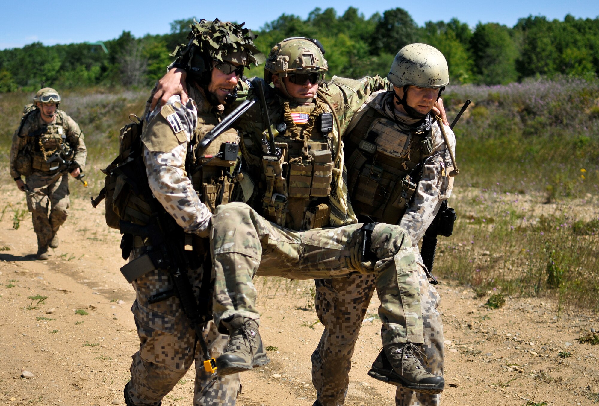 Latvian Capt. Armands Rutkis (left) and Cpl. Janis Gabranis (right), both tactical air control party specialists with the Latvian National Armed Forces, carry U.S. Air Force Senior Airman Lance A. Liggett to a medical evacuation point after a simulated roadside bomb explosion at Operation Northern Strike in Grayling Air Gunnery Range, Grayling, Mich., Aug. 14, 2014. Northern Strike was a 3-week-long exercise led by the National Guard that demonstrated the combined power of joint and multinational air and ground forces. TACPs with the Air National Guard’s 169th ASOS from Peoria, Ill., and more than 5,000 other armed forces members from 12 states and two coalition nations participated in the combat training. (U.S. Air National Guard photo by Staff Sgt. Lealan Buehrer/Released)