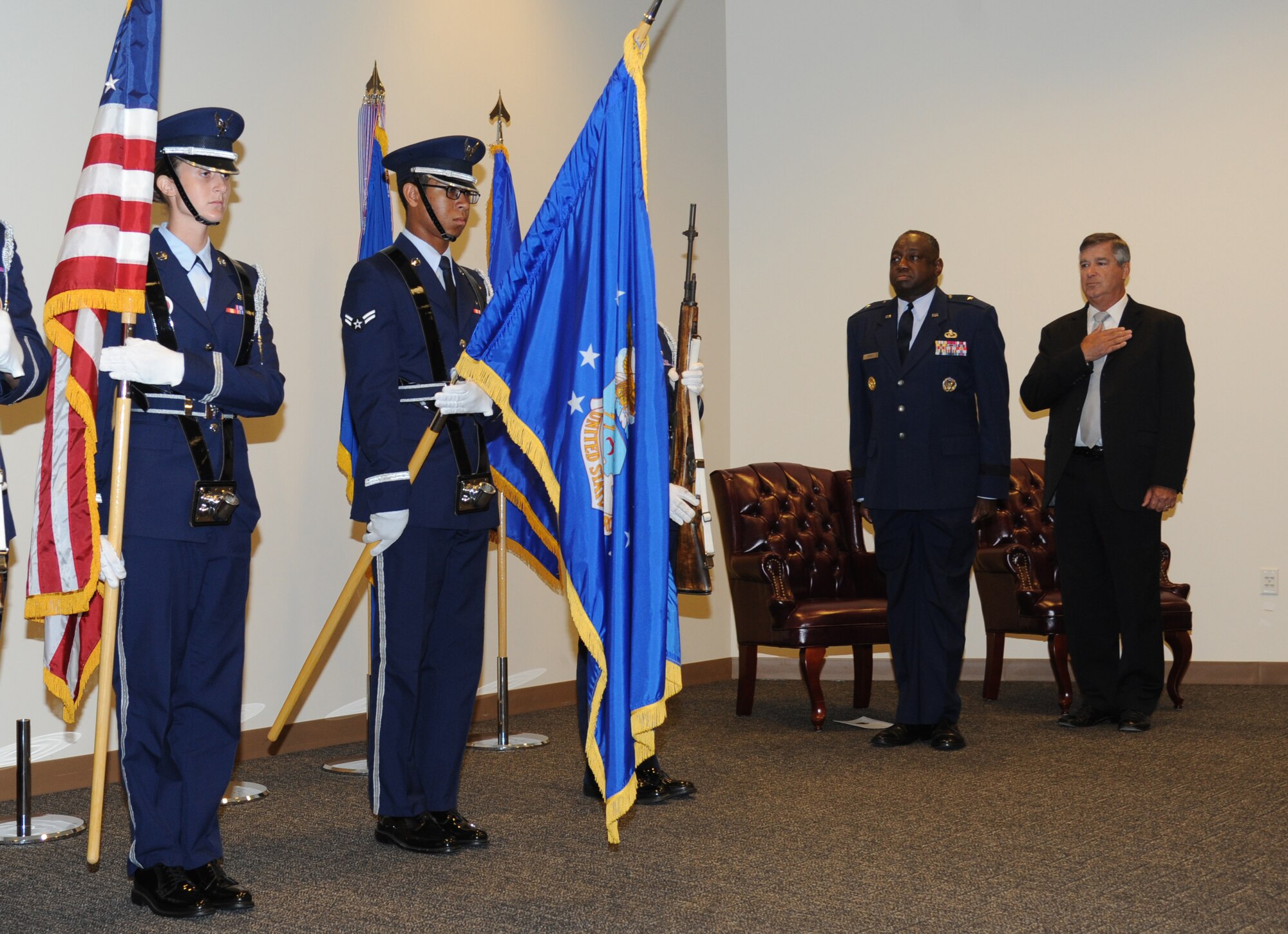 Brig. Gen. Mark Brown, 2nd Air Force commander, and James Hollingsworth, 2nd Air Force, stand as the Keesler Honor Guard post the colors and the National Anthem is sung during Hollingsworth’s retirement ceremony Aug. 25, 2014, at the Roberts Maintenance Facility, Keesler Air Force Base, Miss.  He retired with more than 45 years of combined military and civilian service.  Brown was the officiating officer for the event. (U.S. Air Force photo by Kemberly Groue) 