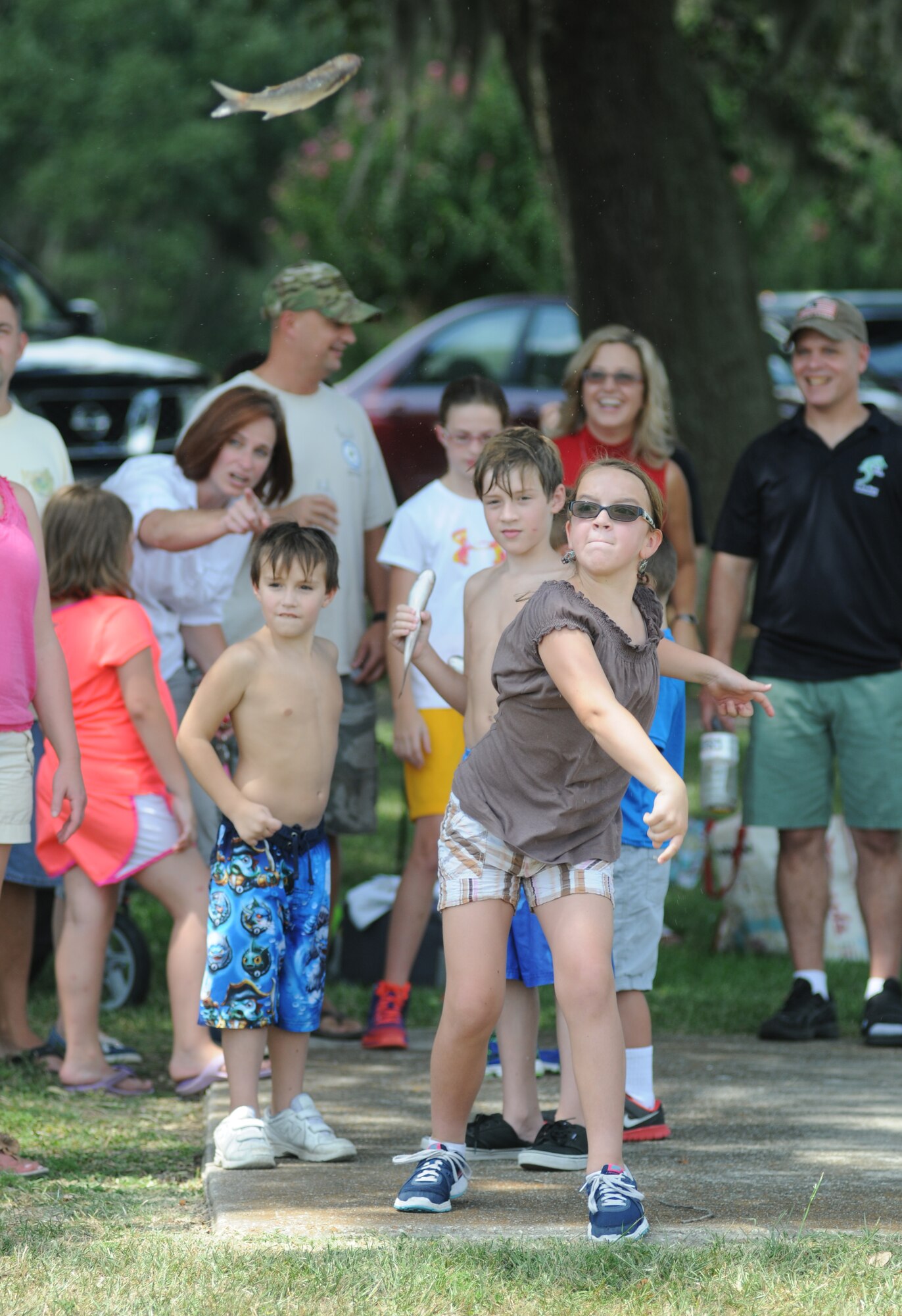 The daughter of Maj. Kelly Nation, 81st Medical Operations Squadron, participates in the Mullet toss competition during the BBQ on the Bay event Aug. 23, 2014, at the Marina Park, Keesler Air Force Base, Miss.  Entertainment also included live music and BBQ.  (U.S. Air Force photo by Kemberly Groue)