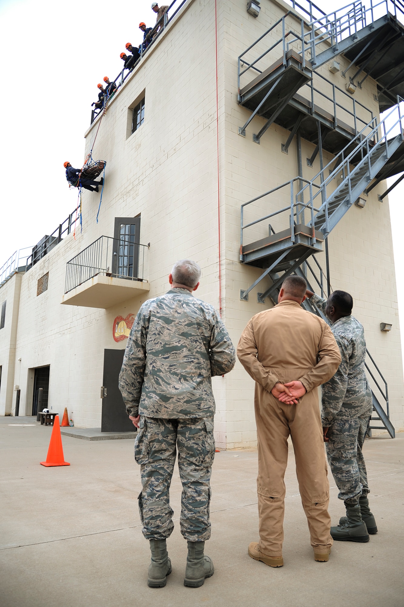GOODFELLOW AIR FORCE BASE, Texas -- Brig. Gen. Mark Brown, Second Air Force Commander, right, watches a student rappel down a building at the Louis F. Garland Department of Defense Fire Academy Aug. 21. Gen. Brown toured the Fire Academy as well as the 315th and 316th Training Squadrons. (U.S. Air Force Photo/ Airman 1st Class Devin Boyer)