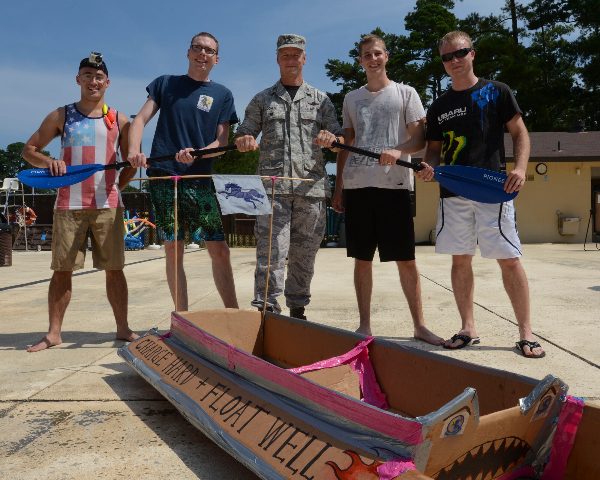 U.S. Air Force Col. Bill Jones, 20th Fighter Wing vice commander (center), stands with 20th Operational Support Squadron’s “Mustangs” team, for a photo after participating in the cardboard regatta at Shaw Air Force Base, S.C., Aug. 22, 2014. The boat race was part of Comprehensive Airman Fitness and Big “A” Appreciation Day, some activities that took place included a formation run, cardboard regatta, amazing race and cornhole. (U.S. Air Force photo by Senior Airman Tabatha Zarrella/Released)
