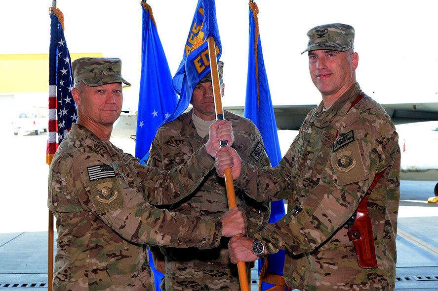 U.S. Air Force Brig. Gen. Mark D. Kelly, 455th Air Expeditionary Wing commander passes command of the 455th Expeditionary Operations Group to U.S. Air Force Col. Jon C. Wilkinson as he assumes command during the assumption of command ceremony held Aug. 26, 2014 at Bagram Airfield, Afghanistan. Wilkinson is now responsible for all expeditionary flying and aeromedical evacuation operations for the 455th Air Expeditionary Wing. (U.S. Air Force photo by Master Sgt. Cohen A. Young/Released)