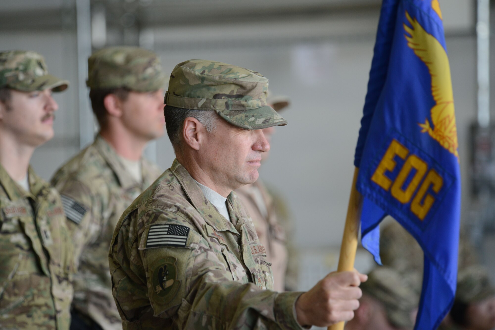U.S. Air Force Chief Master Sgt. David Murphy, 455th Expeditionary Operations Group Chief stands at parade rest in a formation while holding the group guidon during the 455 EOG Assumption of Command ceremony at Bagram Airfield, Afghanistan Aug. 26, 2014.  U.S. Air Force Brig. Gen. Mark D. Kelly, 455th Air Expeditionary Wing commander, passed control of the 455 EOG to Col. Jon C. Wilkinson. (U.S. Air Force photo by Master Sgt. Cohen A. Young/Released)
