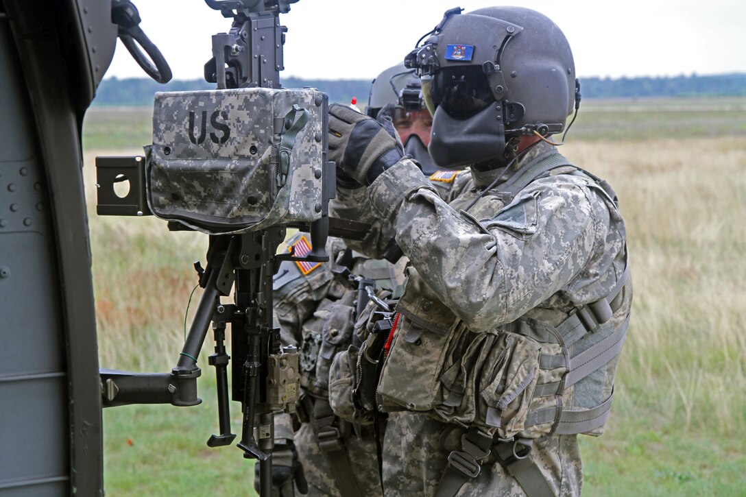 Sgt. Eric Wolschleger, a Soldier assigned to Bravo Company, 1st Battalion, 147th Aviation Battalion, Wisconsin Army National Guard, performs maintenance and lubricates the M240G machine gun mounted on a UH-60M Black Hawk helicopter before a live-fire exercise at the Grayling Army Airfield, Mich., Aug. 11, 2014. The crew ran door-gunnery exercises at the 40 Complex on Camp Grayling Joint Maneuver Training Center during operation Northern Strike 2014, a major air-to-ground training exercise hosted by the Michigan National Guard to meet the training needs of 24 units from 12 states. (U.S. Army photo by Spc. Seth LaCount, 126th Press Camp, Army National Guard)