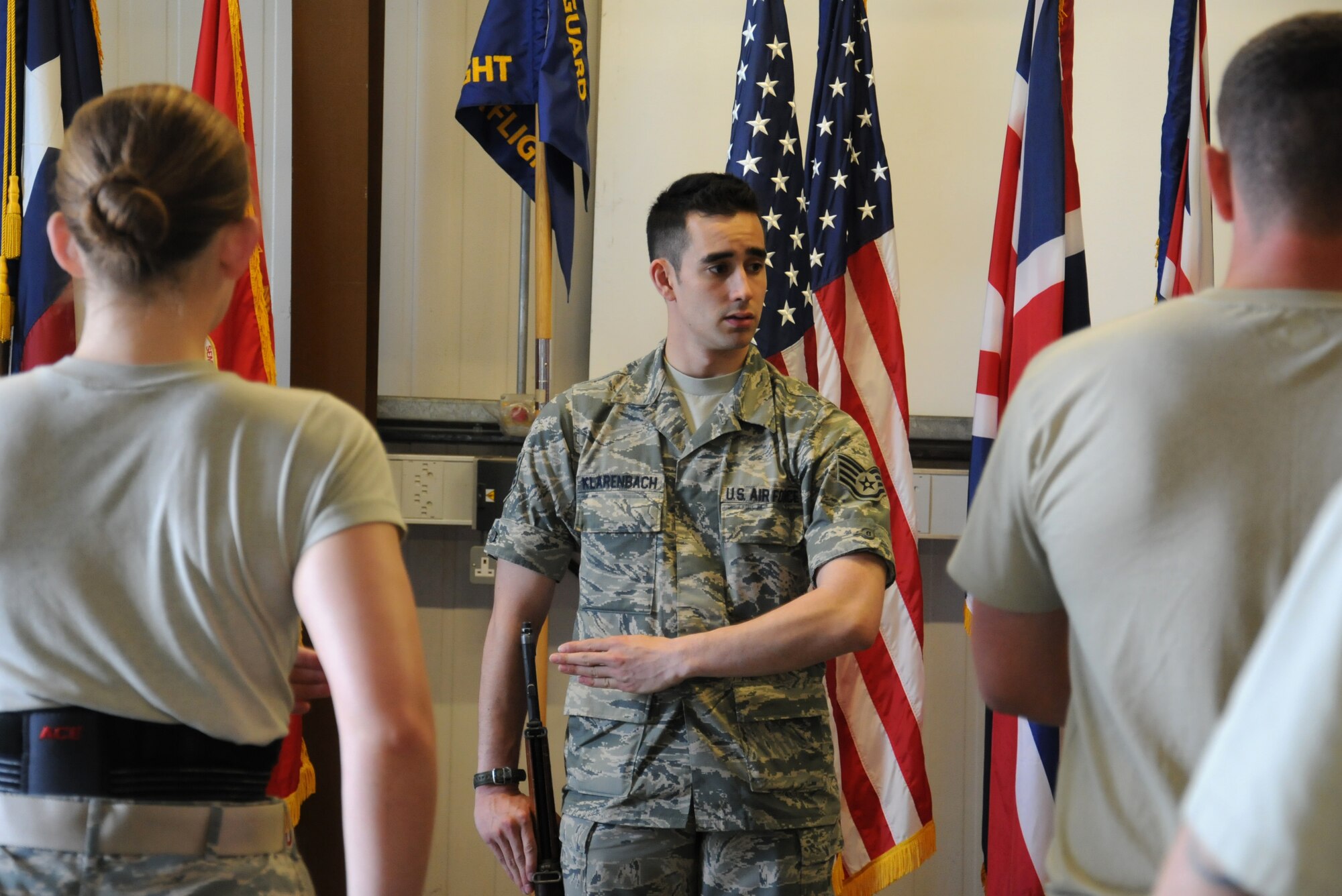 U.S. Air Force Staff Sgt. Aaron Klarenbach, 352nd Special Operations Maintenance Squadron aerospace propulsion journeyman from Vancouver, Wash., trains Airmen of the honor guard how to Order Arms during weekly training Aug. 5, 2014, on RAF Mildenhall, England. The honor guard practices every Tuesday from 3 to 5 p.m. and the second Tuesday of the month is an all day practice. (U.S. Air Force photo/Gina Randall/Released)
