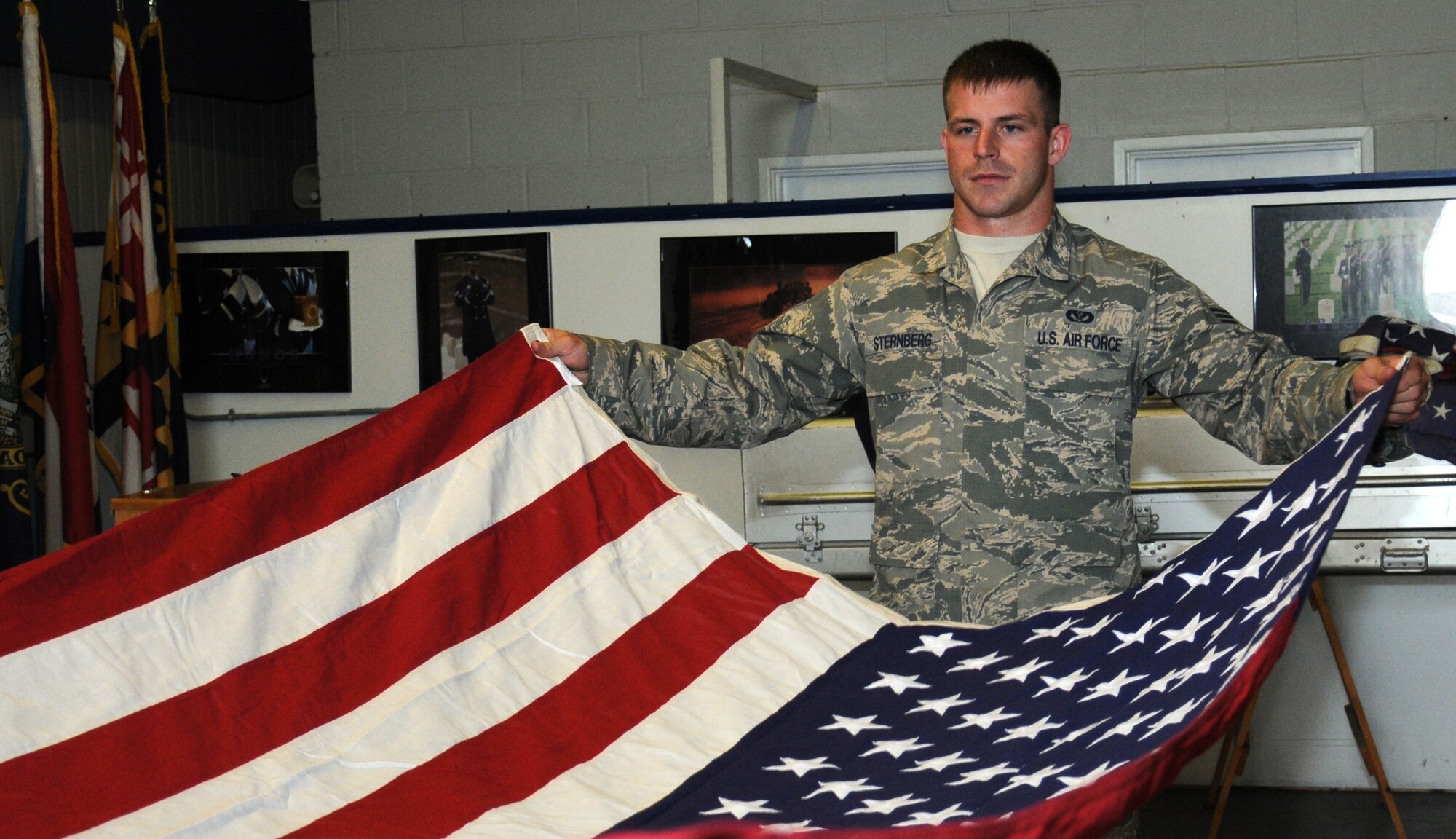 U.S. Air Force Senior Airman Michael Sternberg, 100th Civil Engineer Squadron pavement and construction equipment operator from Panhandle, Texas, practices flag folding during weekly honor guard training Aug. 5, 2014, on RAF Mildenhall, England. Traditions are a valued part of the Air Force and its history, and are passed down from generation to generation. (U.S. Air Force photo/Gina Randall/Released)
