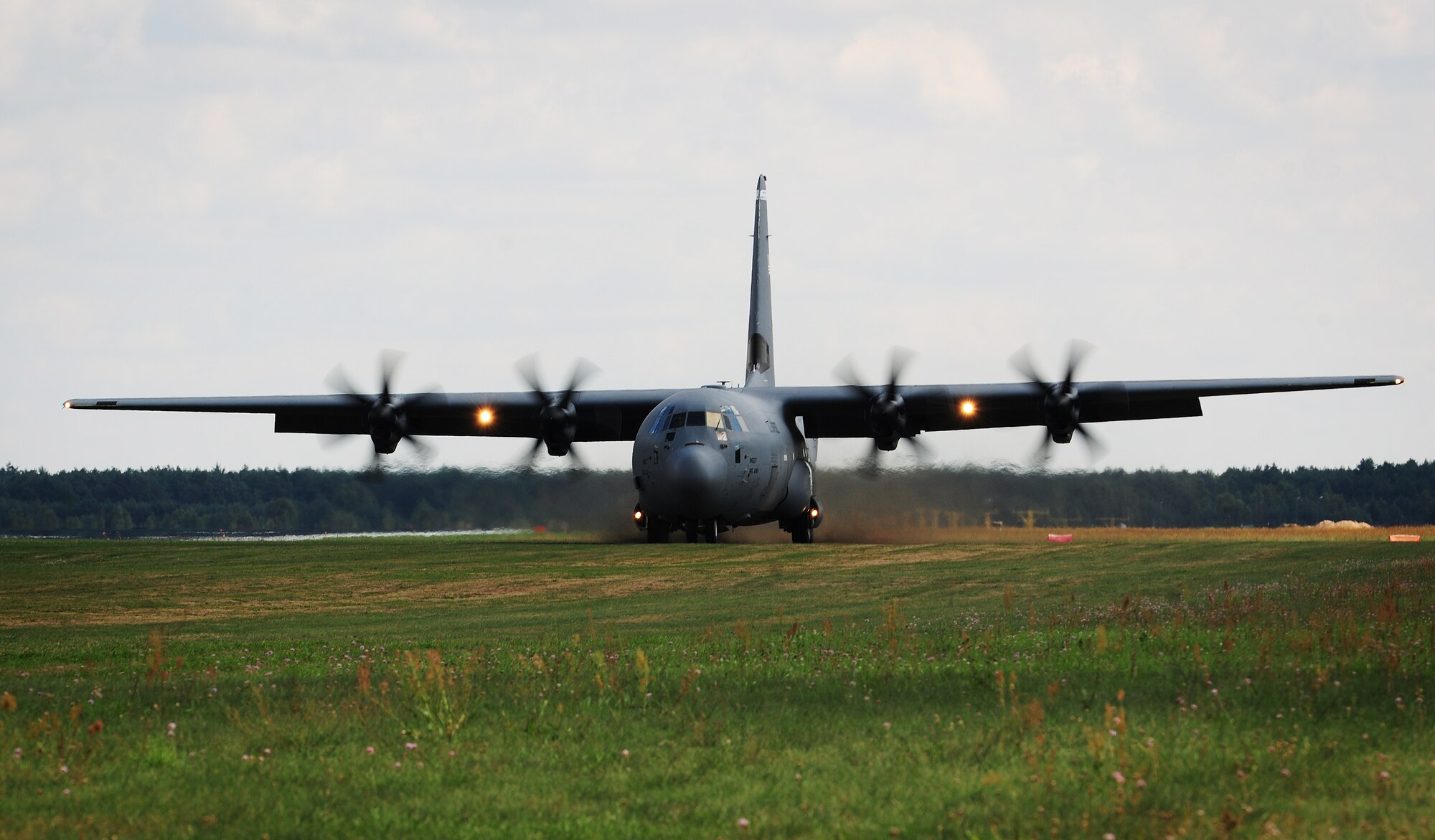 A C-130J Super Hercules lands on an unimproved runway at Powidz Air Base, Poland, Aug. 25, 2014. Throughout the deployment to Poland, Airmen were able to work with NATO partners to develop and improve forces capable of maintaining regional security. (U.S. Air Force photo by Staff Sgt. Jarad A. Denton/Released)