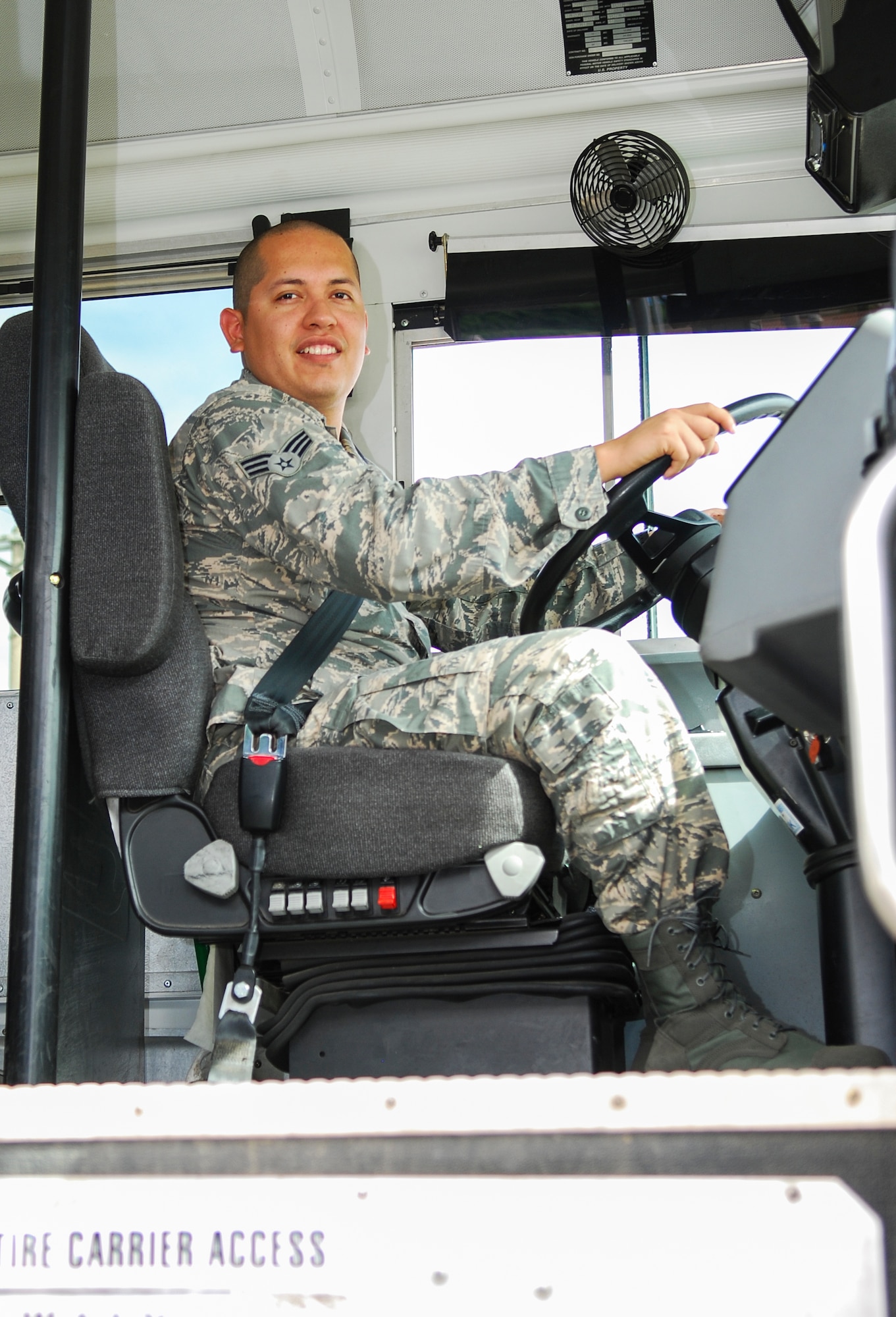 Senior Airman Jack Cortez, 374th Logistical Readiness Squadron vehicle operator, greets passengers as they get on a bus at Osan Air Base, South Korea, during Ulchi Freedom Guardian, Aug. 25, 2014. Cortez gave augmentees an opportunity for additional down-time by providing transportation to and from military members’ work sections. (U.S. Air Force photo by Senior Airman Racheal E. Watson/Released)