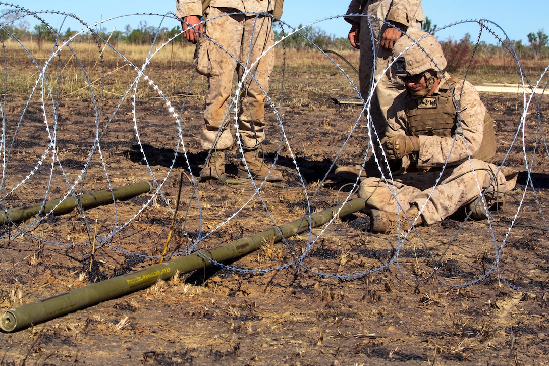 U.S. Marine Corps Cpl. Nathan K.L. Liska ties detonation cord to a ...