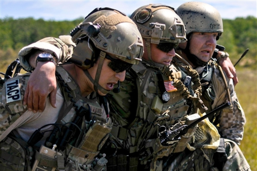 U.S. Air Force Senior Airman Thomas Vamvakos, left, and Latvian Cpl. Janis Gabranis, right, carry U.S. Air Force Senior Airman Lance A. Liggett to a medical evacuation point after a simulated roadside bomb explosion during Operation Northern Strike 2014 on a gunnery range in Grayling, Mich., Aug. 14, 2014. Vamvakos and Liggett are tactical air control party specialists assigned to the 169th Air Support Operations Squadron. 