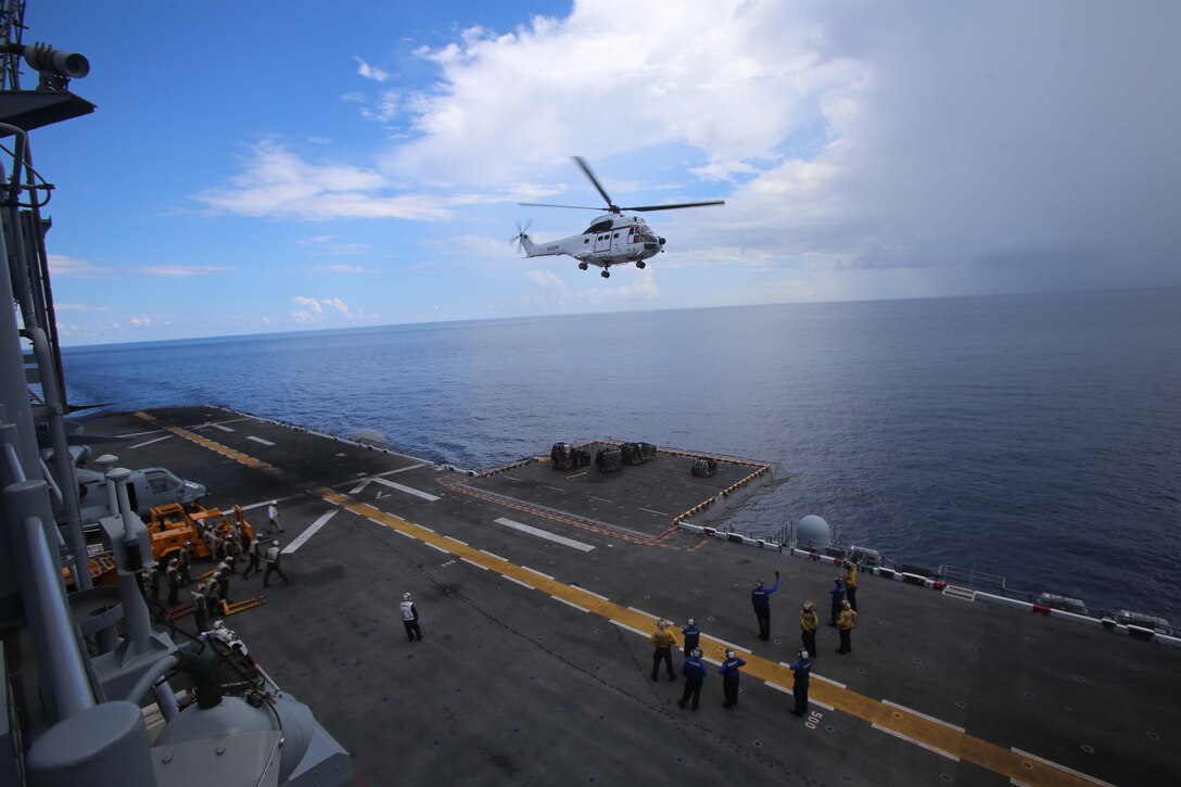 An AS-332 Super Puma delivers cargo to the flight deck of the USS Makin Island during a replenishment at sea (RAS) as part of the 11th Marine Expeditionary Unit’s WESTPAC 14-2 deployment Aug. 24, 2014. The 11th MEU and Makin Island Amphibious Ready Group are deployed to the U.S. 7th Fleet area of operations as a sea based, expeditionary crisis response force capable of conducting amphibious missions across the full range of military operations. (U.S. Marine Corps photo by Cpl. Demetrius Morgan/RELEASED)  