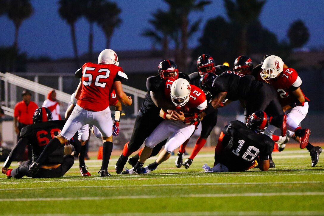 The Miramar Air Station Falcons claimed a 19-8 victory in their opening game of the season against the 1st Marine Division Headquarters Battalion Standard Bearers at the Paige Field House football field here, Aug. 26.  The night was a grueling contest starring two defenses that consistently forced fumbles throughout the night.

(Photo by; Cpl. Keenan Zelazoski)