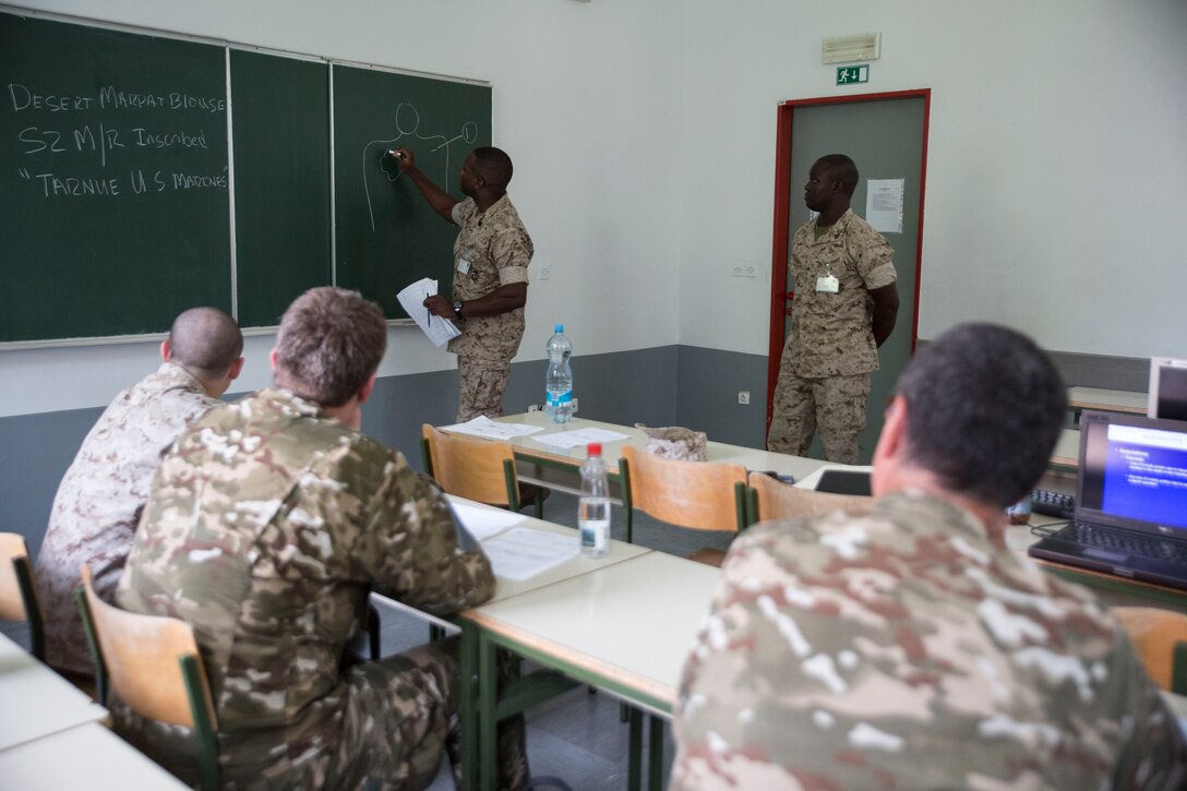 Sgt. Anthony Latney, a platoon sergeant with Personnel Retrieval and Processing Company, 4th Marine Logistics Group, Marine Forces Reserve, demonstrates how to properly identify marks on a fallen Marine’s body to members of the Slovenian army during the Mortuary Affairs class as part of Immediate Response 2014 here, Aug. 21, 2014. While the PRP Marines are already trained to know the process, the Slovenian soldiers are not familiar with how the U.S. conducts PRP.