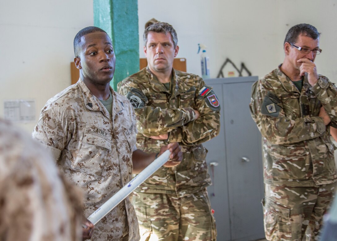 Sgt. Anthony Latney, a platoon sergeant with Personnel Retrieval and Processing Company, 4th Marine Logistics Group, Marine Forces Reserve, speaks with members of the Slovenian army during the Mortuary Affairs class as part of Immediate Response 2014 here, Aug. 21, 2014. While the PRP Marines are already trained to know the process, the Slovenian soldiers are not familiar with how the U.S. conducts PRP.