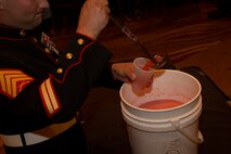 Sgt. Kale Minkie, a recruiter from Recruiting Substation Waukesha, pours himself a cup of “grog” after being fined during Recruiting Station Milwaukee’s first Dining Out, Aug. 20 in Brown Deer, Wis.  The “grog” is a less than appetizing mix of mystery ingredients that Marines may have to drink from if they are caught violating the “Rules of the Mess.”  