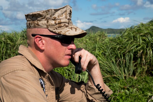 Sgt. Justin Gardner, quality assurance safety observer with Marine Aerial Refueler Squadron 152, communicates with the pilots of a KC-130J Super Hercules during a threat reaction evolution on an island outside of Okinawa, Japan, Aug. 26, 2014. The threat reaction evolution is a chance for pilots to stay up to date on their qualifications while keeping an alert and aware mindset for any arising combat scenario.