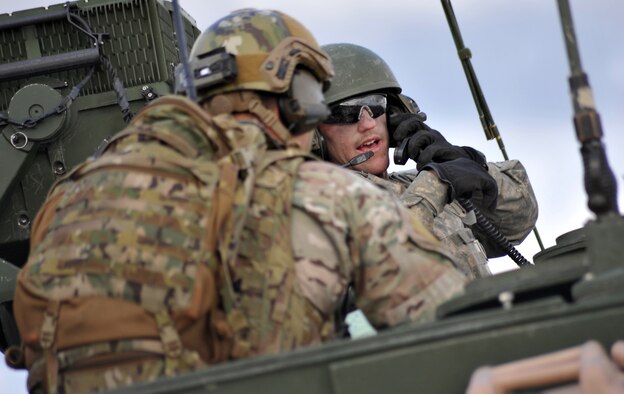 Army Private 1st Class Christopher Maurer, right, turns to talk to a Joint Terminal Attack Controller as Soldiers assigned to the 5th Squadron, 1st Cavalry Regiment, 1st Stryker Brigade Combat Team, U.S. Army Alaska, and U.S. Air Force Air National Guard Joint Terminal Attack Controllers train together at Yukon Training Area, Alaska, to hone joint interoperability and close air support capabilities in a high operations tempo simulated combat environment during the Red Flag-Alaska 14-3 exercise, Thursday, Aug. 21, 2014.  Joint Terminal Attack Controllers deploy with Army units, and bring to the fight an ability to quickly and accurately call close air support to engage enemy targets on the ground. Red Flag-Alaska, a series of Pacific Air Forces commander-directed field training exercises for U.S. forces, provides joint offensive counter-air, interdiction, close air support, and large force employment training in a simulated combat environment. (U.S. Air Force photo/Justin Connaher)