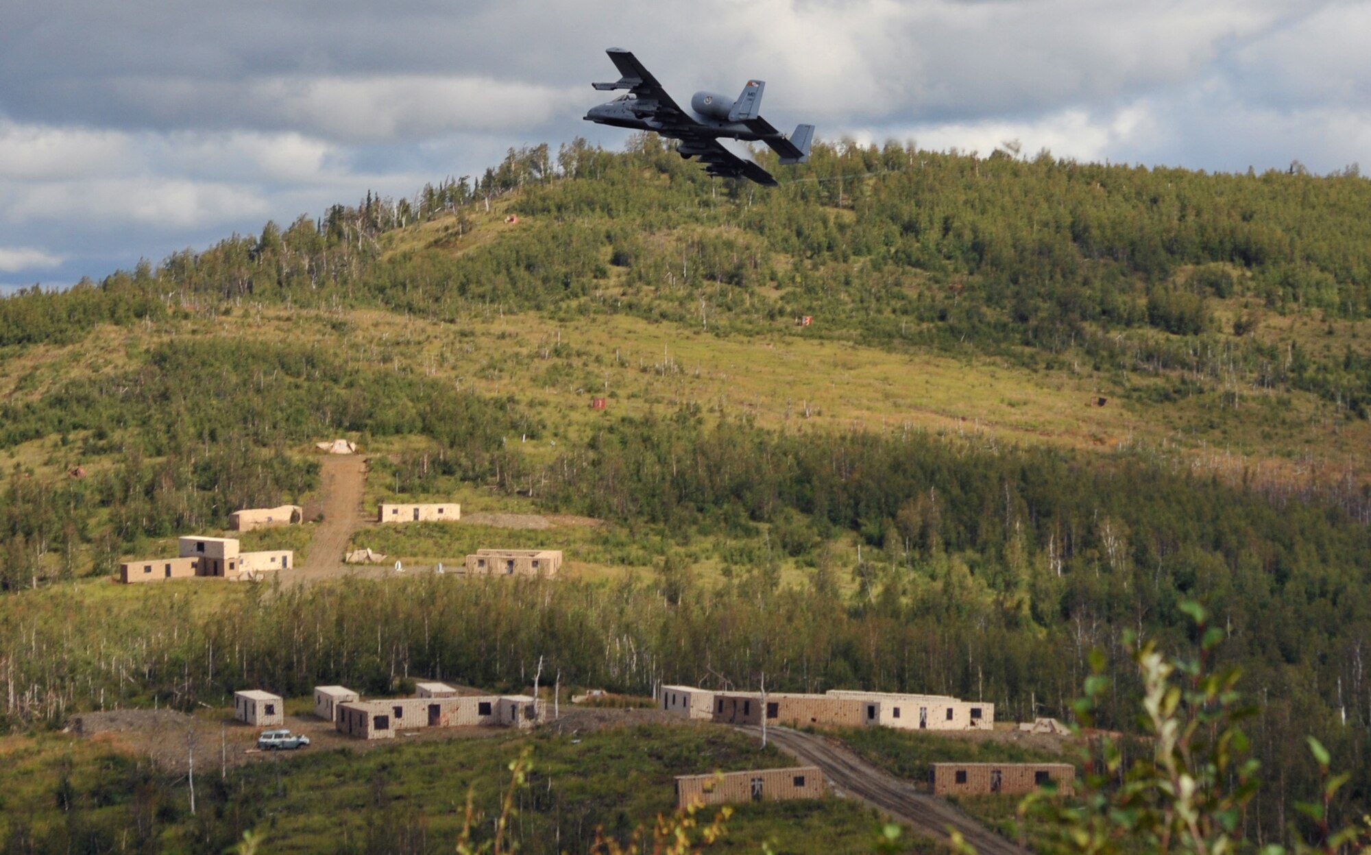 A Fairchild Republic A-10 Thunderbolt II flies over a target area after a strafing run as Soldiers assigned to the 5th Squadron, 1st Cavalry Regiment, 1st Stryker Brigade Combat Team, U.S. Army Alaska, and U.S. Air Force Air National Guard Joint Terminal Attack Controllers train together at Yukon Training Area, Alaska, to hone joint interoperability and close air support capabilities in a high operations tempo simulated combat environment during the Red Flag-Alaska 14-3 exercise, Wednesday, Aug. 20, 2014.  Joint Terminal Attack Controllers deploy with Army units, and bring to the fight an ability to quickly and accurately call close air support to engage enemy targets on the ground. Red Flag-Alaska, a series of Pacific Air Forces commander-directed field training exercises for U.S. forces, provides joint offensive counter-air, interdiction, close air support, and large force employment training in a simulated combat environment. (U.S. Air Force photo/2LT Michael Harrington)