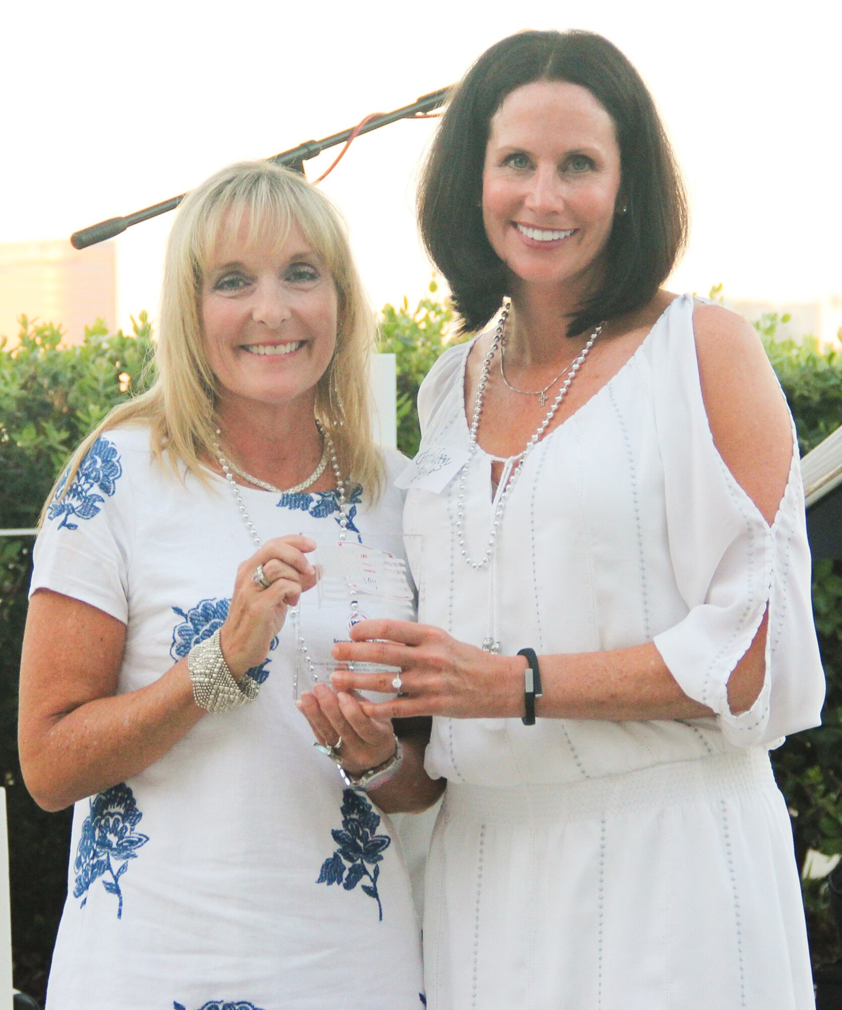 Joy White is presented with the Service to the Flag - Government/Military Award by Kathleen Boyle, president of the Women in Defense Greater Los Angeles Chapter, at the chapter's annual White Party on August 15. (Photo courtesy of Women in Defense)
