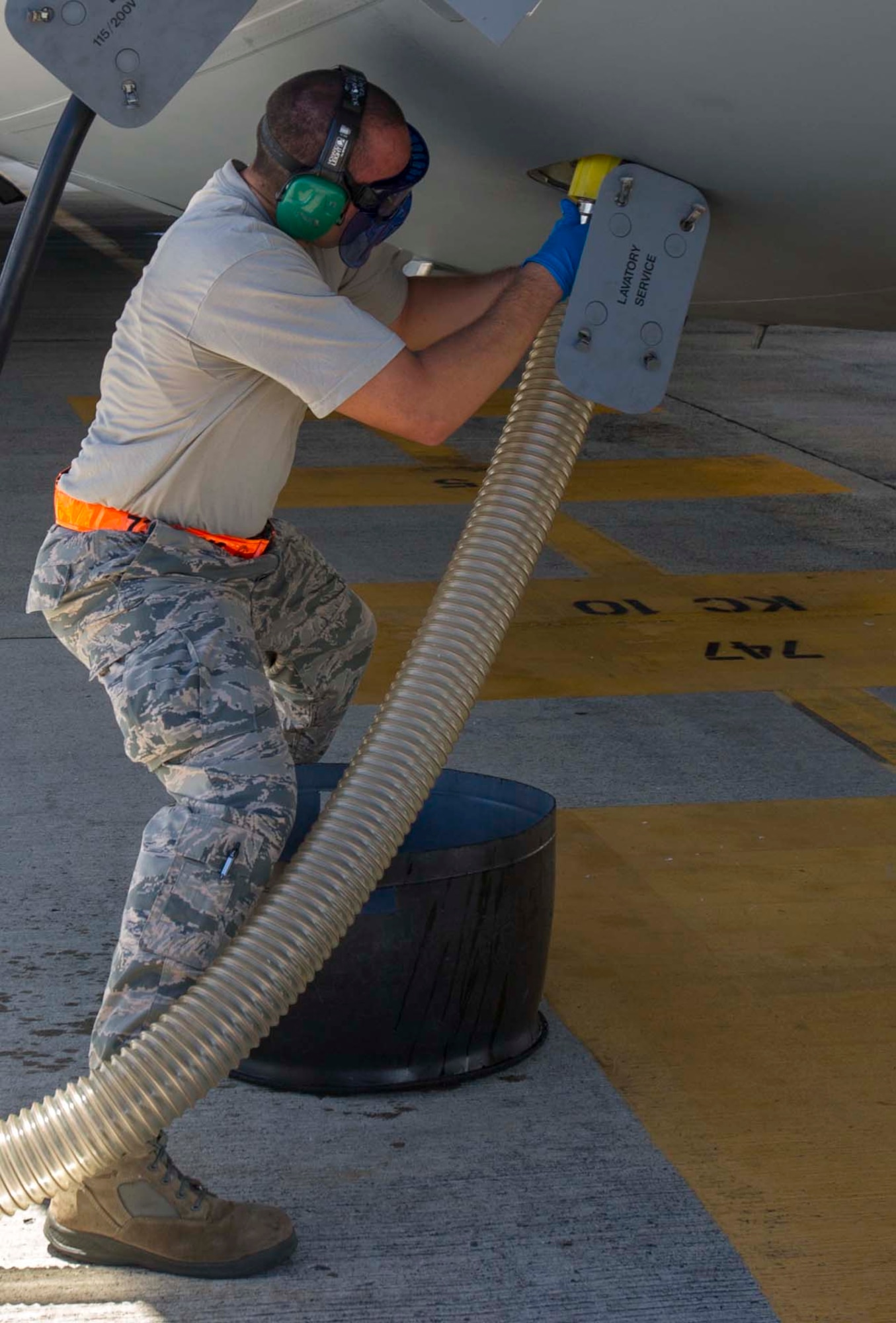 Tech. Sgt. Alejandro Lopez, 735th Air Mobility Squadron noncommissioned officer in charge of aircraft services, attaches a waste water disposal hose to a C-17 Globemaster III during the de-fleeting process on the Joint Base Pearl Harbor-Hickam, Hawaii, flightline Aug. 26, 2014. During de-fleeting, waste water is removed from aircraft using a lavatory service truck, and replaced with “blue juice” in preparation for the next flight. (U.S. Air Force photo by Tech. Sgt. Terri Paden)