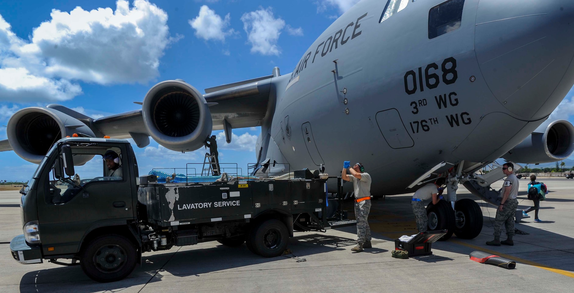 Senior Airman Coby Hargrove, 735th Air Mobility Squadron air freight journeyman, backs a lavatory service truck up to a C-17 Globemaster III in preparation for de-fleeting the aircraft on the Joint Base Pearl Harbor-Hickam, Hawaii, flightline Aug. 26, 2014. During de-fleeting, waste water is removed from aircraft using a lavatory service truck, and replaced with “blue juice” in preparation for the next flight. (U.S. Air Force photo by Tech. Sgt. Terri Paden)