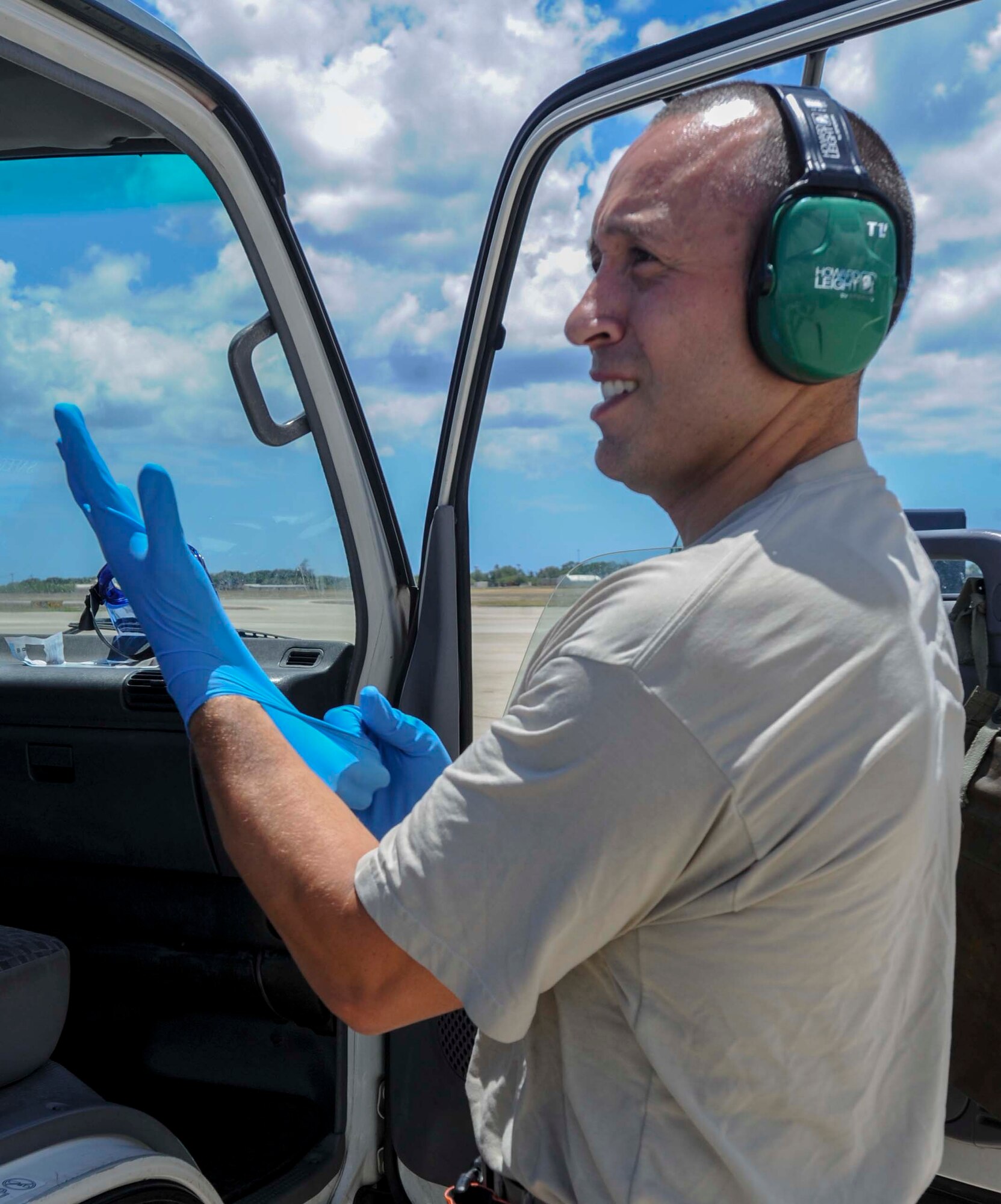 Tech. Sgt. Alejandro Lopez, 735th Air Mobility Squadron noncommissioned officer in charge of aircraft services, dons a pair of gloves in preparation for de-fleeting a C-17 Globemaster III on the Joint Base Pearl Harbor-Hickam, Hawaii, flightline Aug. 26, 2014. During de-fleeting, fleet services Airmen clean and remove the trash and waste water from aircraft. (U.S. Air Force photo by Tech. Sgt. Terri Paden)