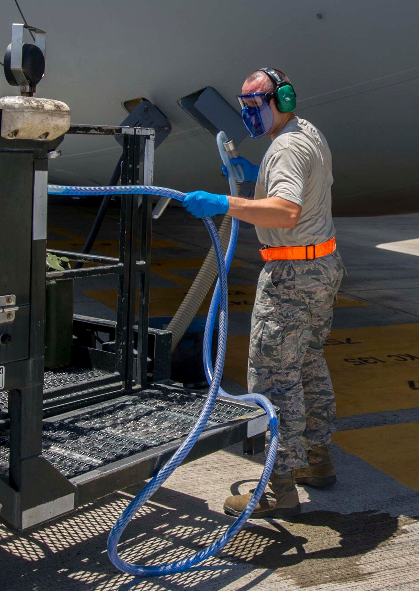 Tech. Sgt. Alejandro Lopez, 735th Air Mobility Squadron noncommissioned officer in charge of aircraft services, prepares to hook a “blue juice” hose up to a C-17 Globemaster III during the de-fleeting process on the Joint Base Pearl Harbor-Hickam, Hawaii, flightline Aug. 26, 2014. During de-fleeting, waste is removed from aircraft using a lavatory service truck, and replaced with “blue juice” in preparation for the next flight. (U.S. Air Force photo by Tech. Sgt. Terri Paden)