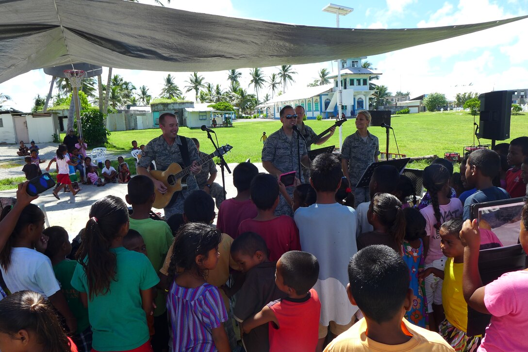 ENNUBIRR ISLAND,The Marshall Islands-- "Small Kine" is pictured here performing people of Ennubirr Island, Aug. 15, 2014. "Small Kine" was the first live band to ever play on this small island, since there isn't any power or running water. "Small Kine" came prepared with a generator and a very talented audio engineer, TSgt Michael Smith! 
(A.F. Photo by TSgt Michael Smith/released)