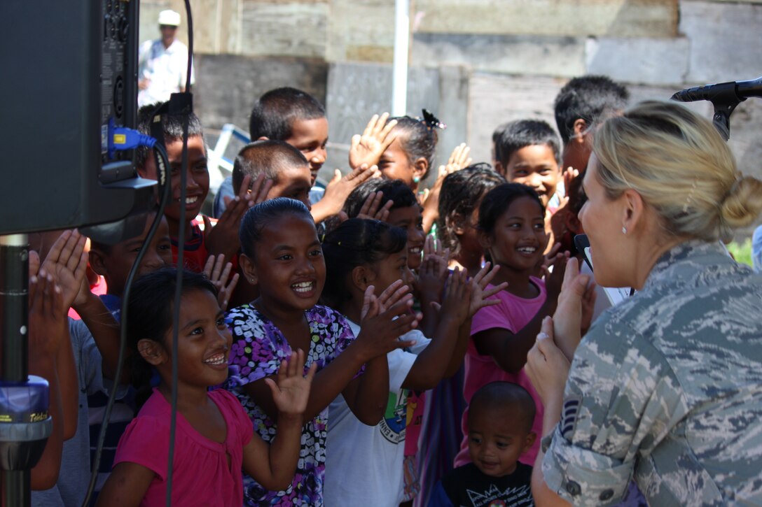 ENNUBIRR ISLAND,The Marshall Islands-- SSgt Courtney Clifford sings to a sea of smiling faces,  Aug. 15, 2014. "Small Kine" was the first live band to ever play on this small island, since there isn't any power or running water. "Small Kine" came prepared with a generator and a very talented audio engineer, TSgt Michael Smith! 
(A.F. Photo by TSgt Michael Smith/released)