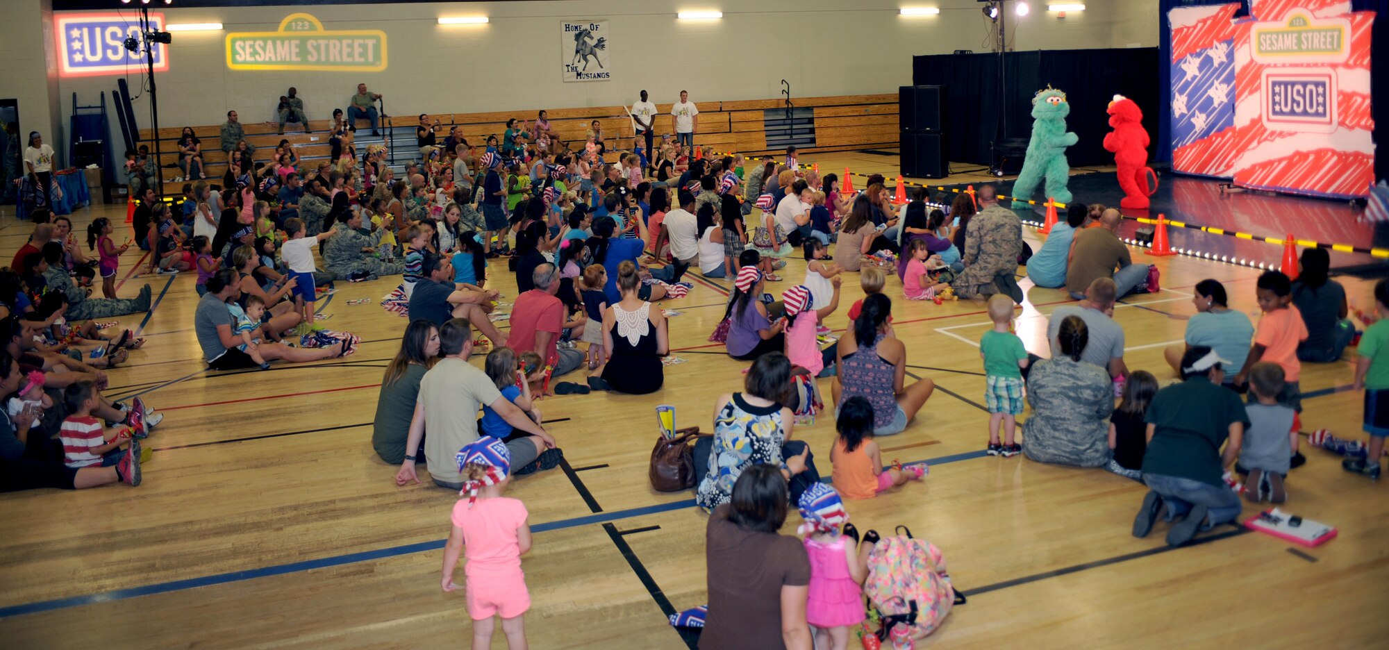 U.S. Air Force families watch the Sesame Street USO Experience for Military Families at Benko Fitness Center at Davis-Monthan Air Force Base Ariz., Aug 26, 2014. The tour visits installations all over the world to provide military families resources to help deal with deployments, homecomings and frequent relocations.  (U.S. Air Force photo by Airman 1st Class Cheyenne Morigeau/ Released)