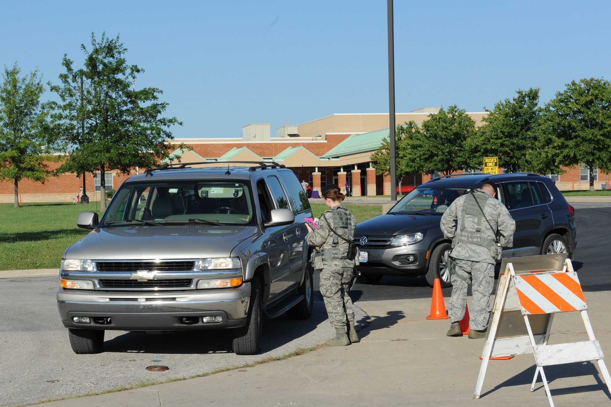 Members of the 375th Security Forces Squadron check driver’s identification as they exit Scott Elementary School and enter Scott Air Force Base, Ill. Drivers crossing from the elementary school to the base need to have their government ID card and a pink card from the school, giving them authorization to enter the base. (U.S. Air Force photo by Senior Airman Sarah Hall-Kirchner/Released)