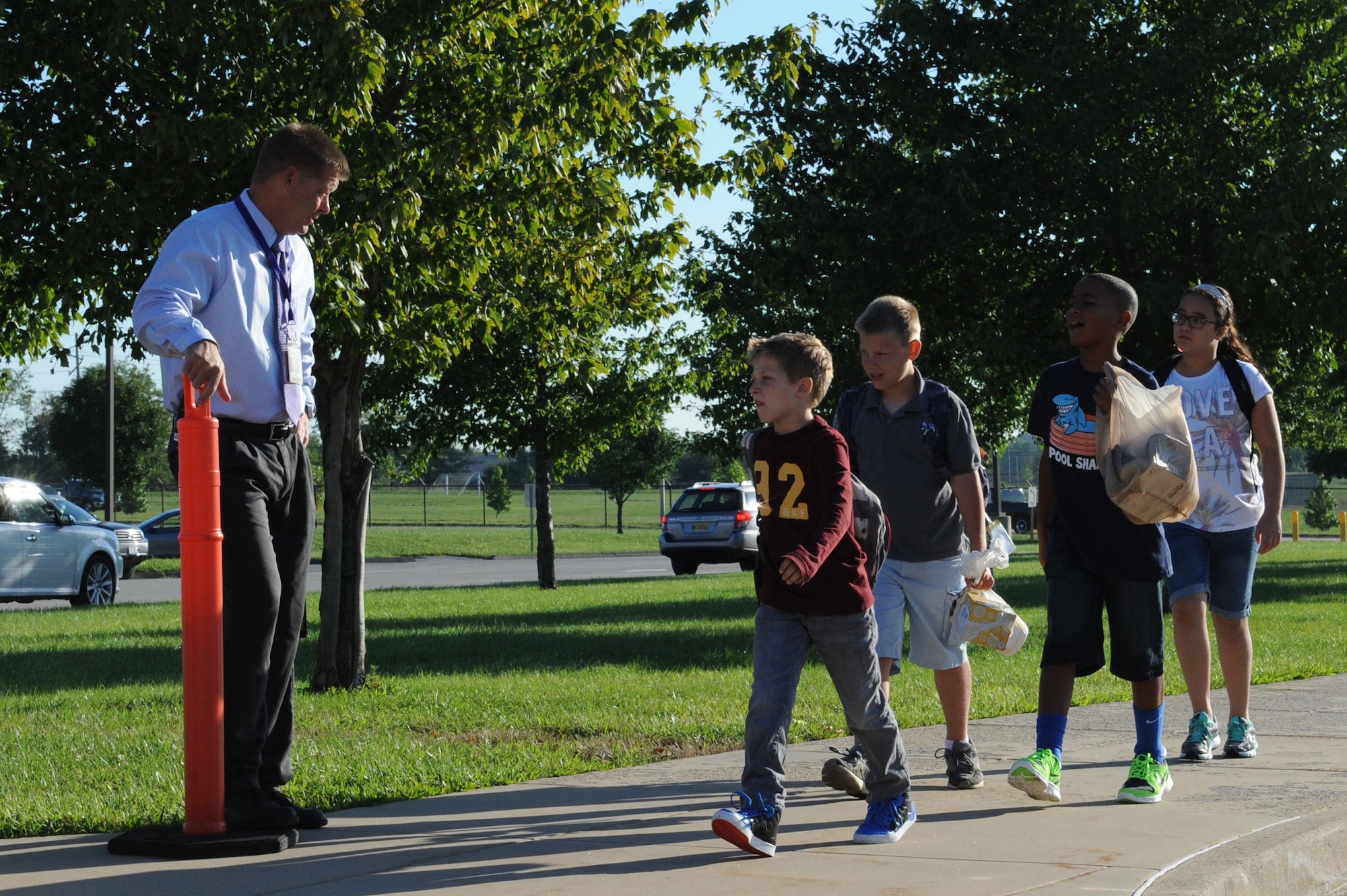 Fritz Holcomb, Scott Elementary School assistant principal, greets students as they depart the bus on the first day of school at Scott Air Force Base, Ill. on August 13, 2014. Students get to school in a variety of ways, such as walking, riding a bus, or being dropped off by car. (U.S. Air Force photo by Senior Airman Sarah Hall-Kirchner/Released)