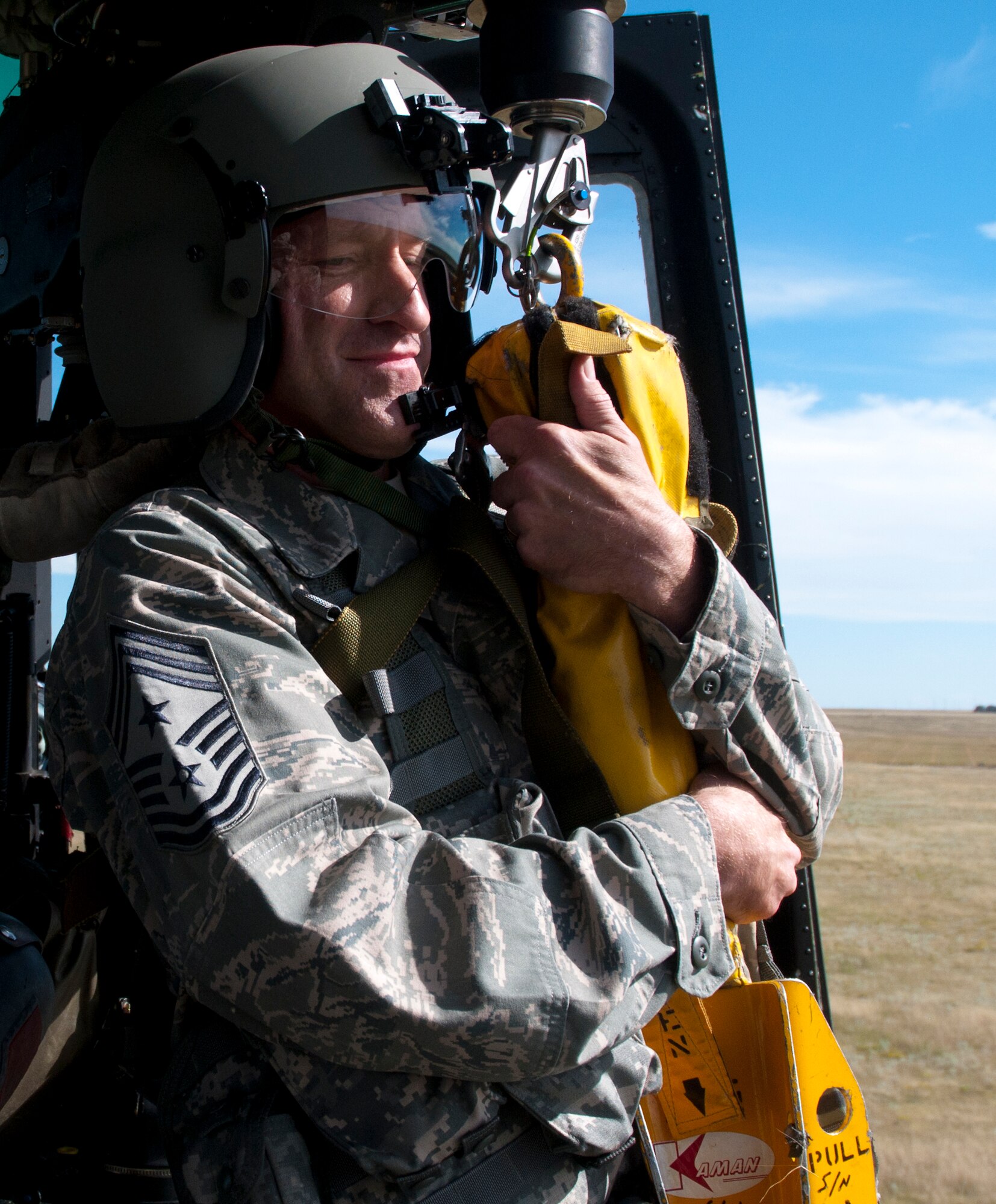 Chief Master Sgt. Samuel Couch, 90th Missile Wing command chief, is pulled into the cabin of a UH-1N Helicopter after being hoisted 40 feet below the helicopter Aug. 25, 2014. This training flight was Couch’s first time flying in one of the 37th Helicopter Squadron’s UH-1N Helicopters. The 37h HS conducts a training flight and demonstrates the capabilities of the squadron to Col. Tracey Hayes, 90th Missile Wing commander, and Chief Samuel Couch, 90th Missile Wing command chief.