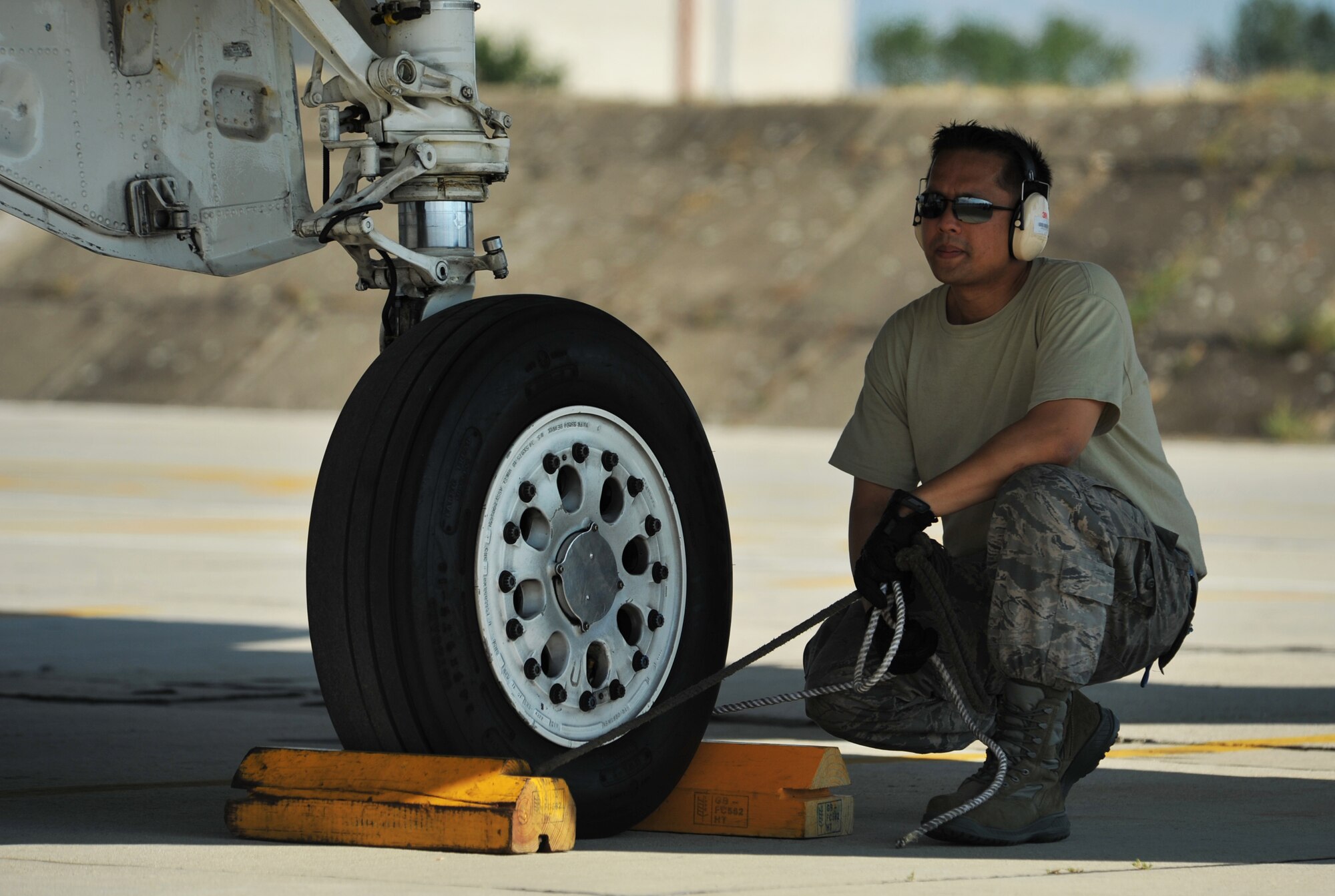 An Airman from the 493rd Aircraft Maintenance Unit waits for the signal to remove the chalks from the wheels of the aircraft at Graf Ignatievo Air Base near Plovdiv, Bulgaria, Aug. 18, 2014. Maintenance Airmen have an important job by keeping the aircraft mission ready. (U.S. Air Force photo/Senior Airman Hailey Haux)