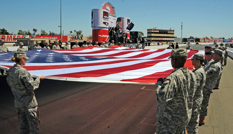Team Beale and members of the California State Military Reserve hold a large American flag during the opening ceremonies of the IndyCar GoPro Grand Prix Aug. 24, 2014, at Sonoma Raceway in Sonoma Calif. Approximately 30 Beale Airmen and more than 100 military members performed during the opening ceremonies. (U.S. Air Force photo by Airman 1st Class Ramon A. Adelan/ Released)