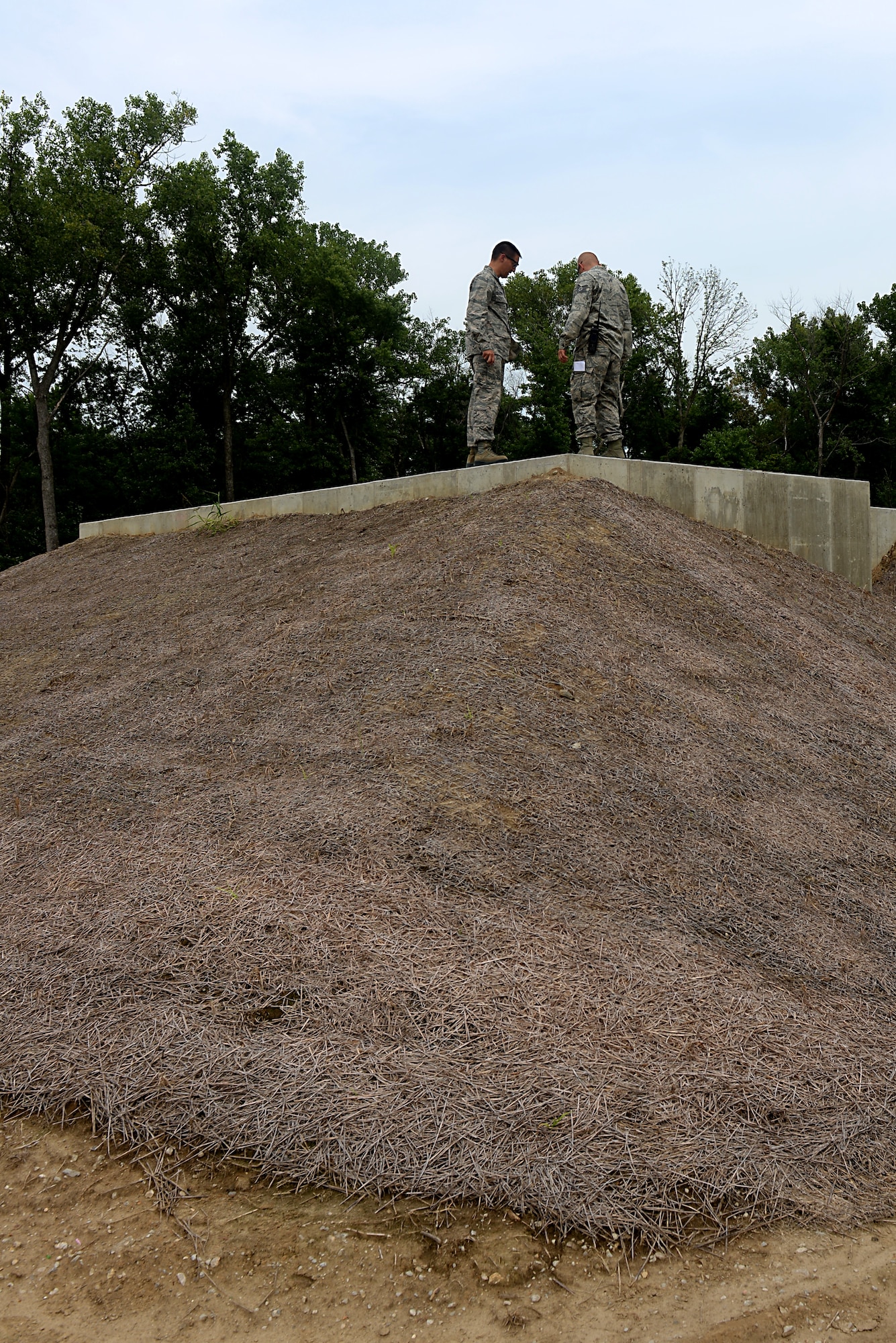 Tech. Sgt. Dustin Lambries shows Col. Kyle Kremer the Explosive Ordnance Proficiency Range bunker used to practice handling explosives Aug. 22, 2014, at Scott Air Force Base, Ill. The team trained extensively without actual explosives until everyone in the flight knew how to operate the materials at the expected standards. Lambries is the 375th Civil Engineer Squadron EOD operations section chief and Kremer is the 375th Air Mobility Wing commander. (U.S. Air Force photo/Senior Airman Jake Eckhardt)