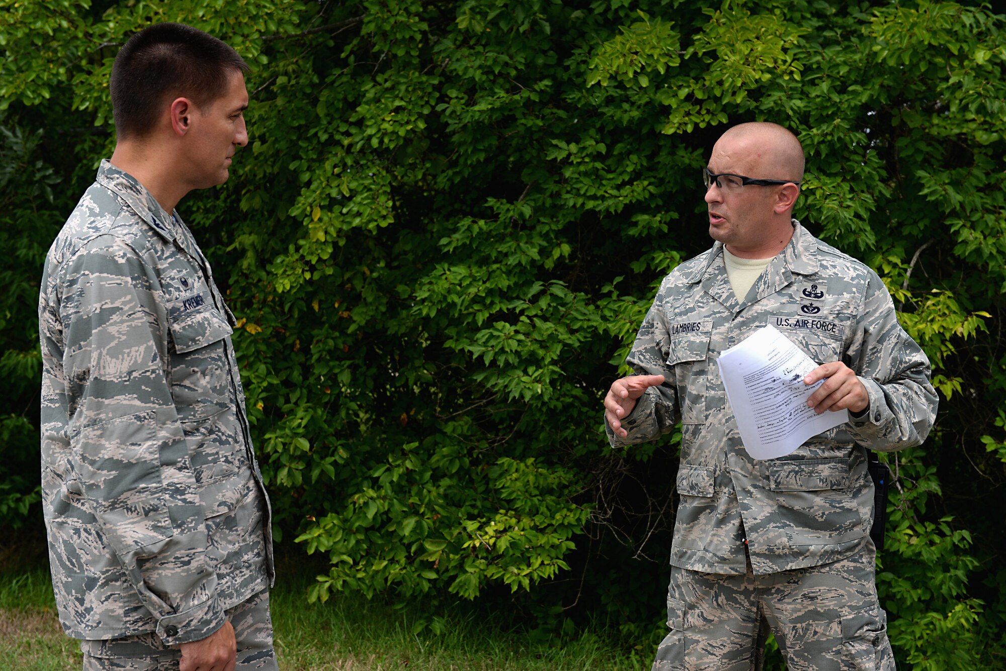 Tech. Sgt. Dustin Lambries briefs Col. Kyle Kremer on appropriate handling of explosives before a demonstration Aug. 22, 2014, at Scott Air Force Base, Ill. During the demonstration, they used two different explosives: C-4 and an aluminum stick roughly three inches long called a cap. Lambries is the 375th Civil Engineer Squadron explosive ordnance disposal operations section chief and Kremer is the 375th Air Mobility Wing commander. (U.S. Air Force photo/Senior Airman Jake Eckhardt)