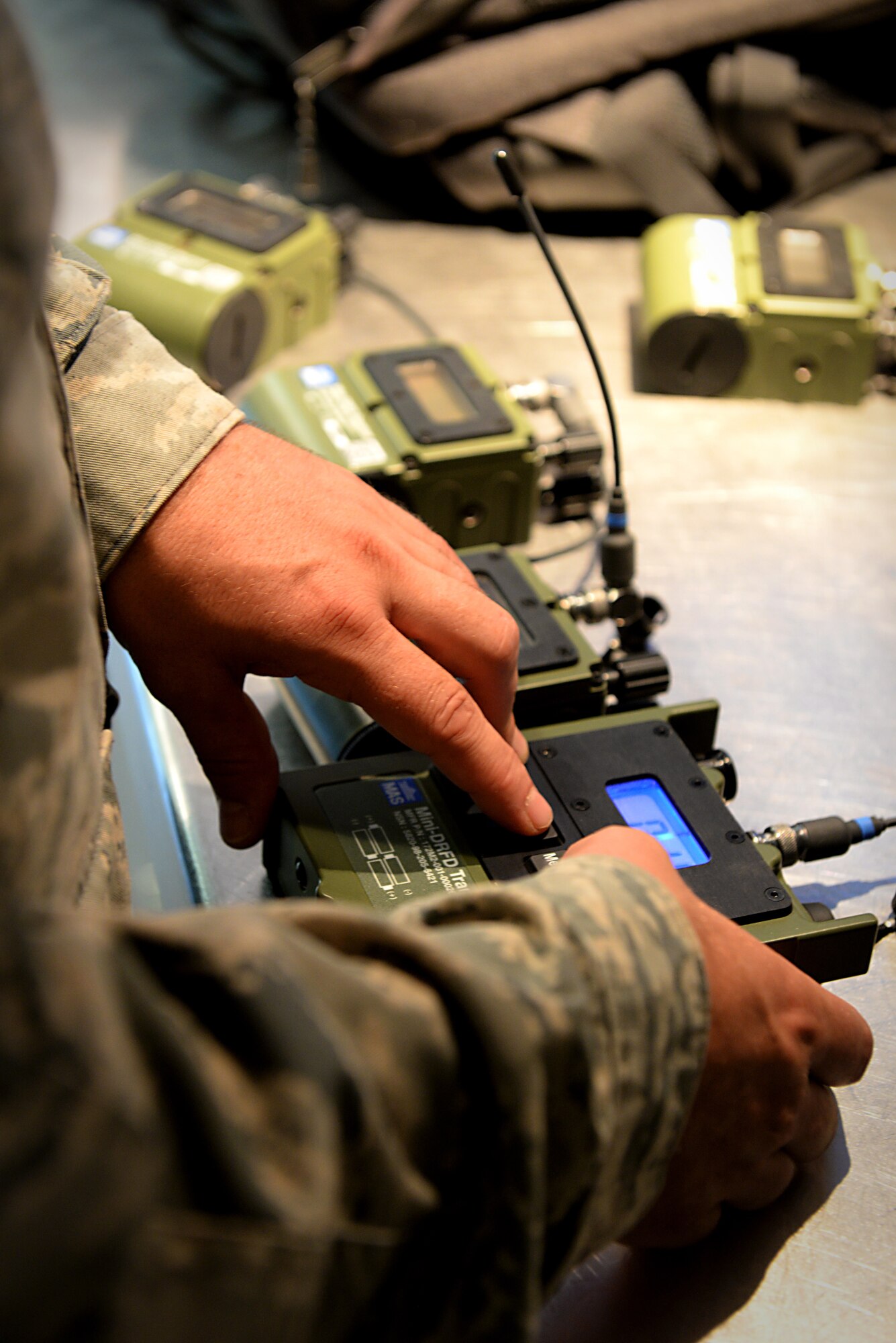 Tech. Sgt. Dustin Lambries syncs the radio transmitters in preparation for an explosion demonstration Aug. 22, 2014, at Scott Air Force Base, Ill. There were three five pound explosives used during the training scenario. Lambries is the 375th Civil Engineer Squadron explosive ordnance disposal operations section chief. (U.S. Air Force photo/Senior Airman Jake Eckhardt)