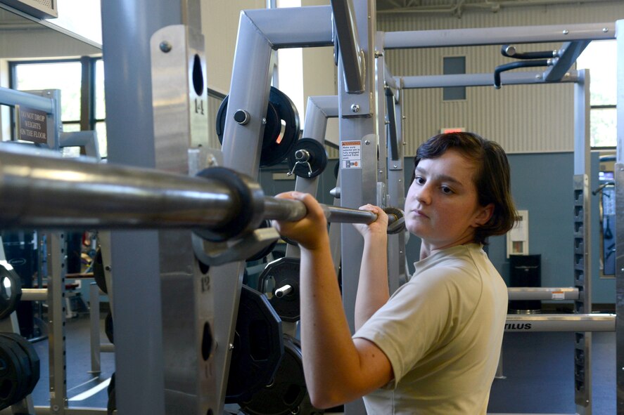 U.S. Air Force Airman 1st Class Serenity Upchurch, 20th Force Support Squadron fitness specialist, re-racks a squat machine at the Shaw Fitness Annex, Shaw Air Force Base, S.C., Aug. 27, 2014. In addition to re-racking equipment, Upchurch is responsible for cleaning machines, monitoring safety, and answering questions from fitness center members. (U.S. Air Force photo by Senior Airman Ashley L. Gardner/Released)